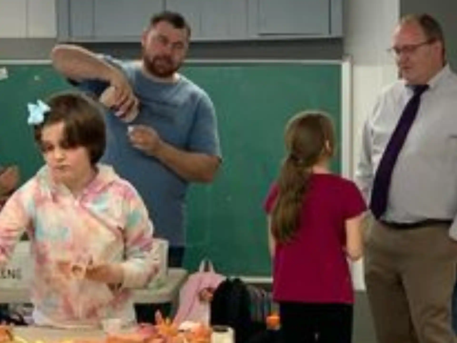 a group of people standing in a room with food on a table