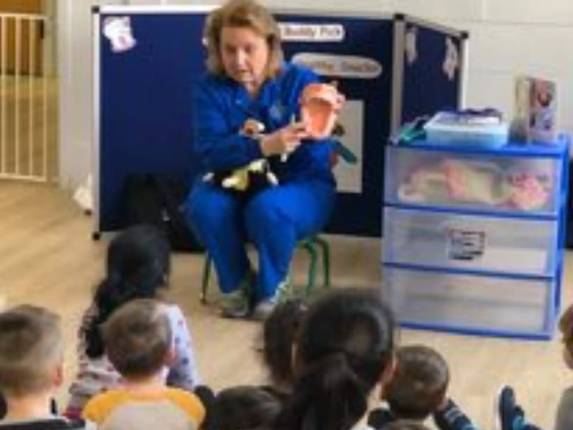 a person sitting in a chair in front of a group of children