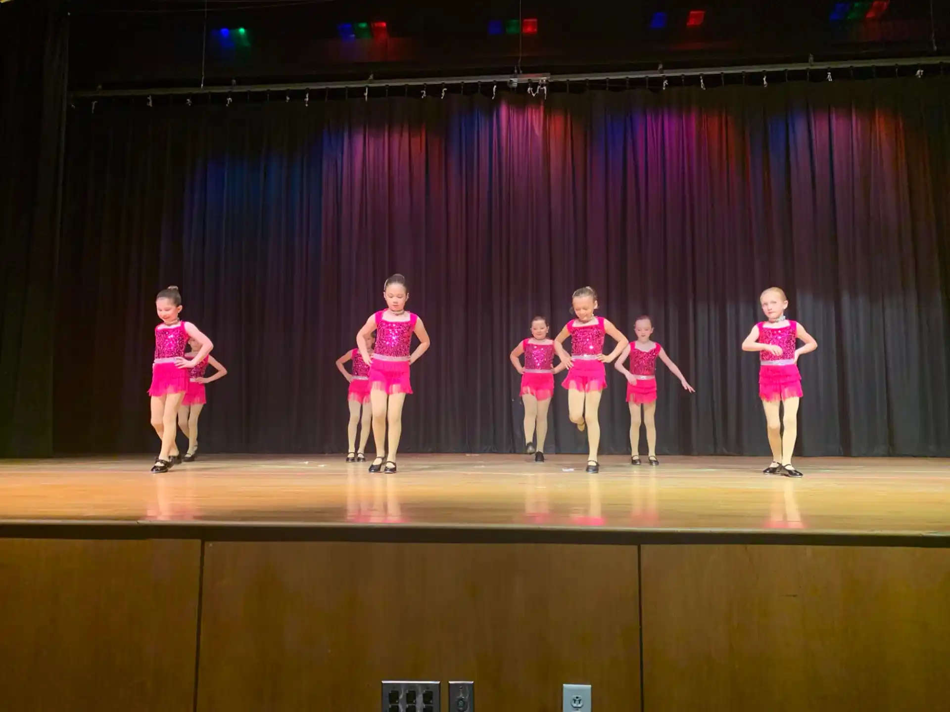 a group of girls in pink uniforms on a stage