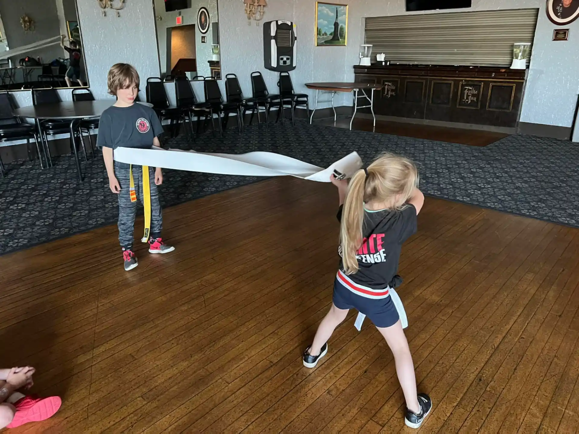 a group of children playing on a mat in a room with chairs and tables