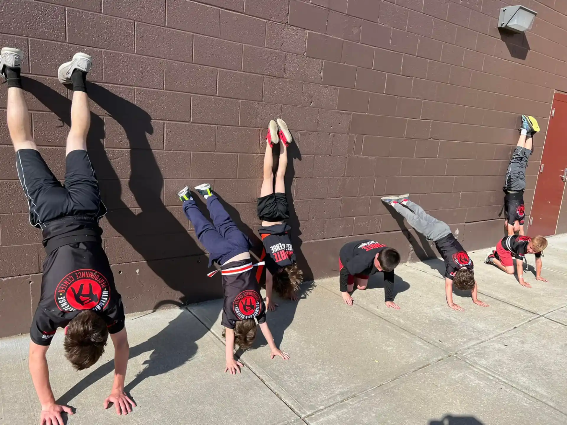 a group of people doing handstands on a brick surface
