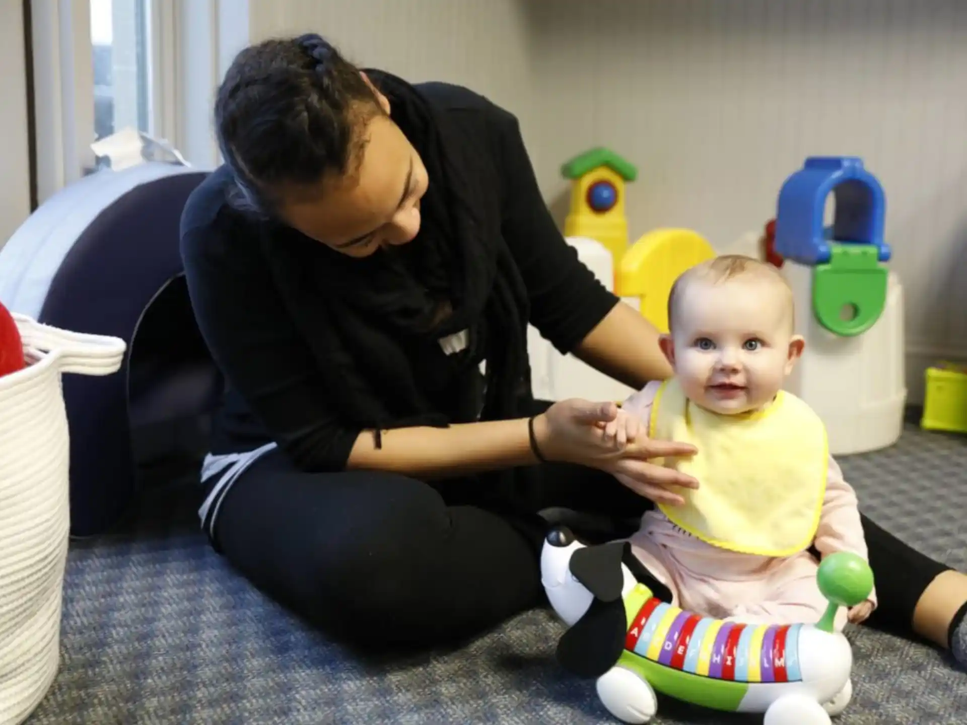 a person sitting on the floor with a baby
