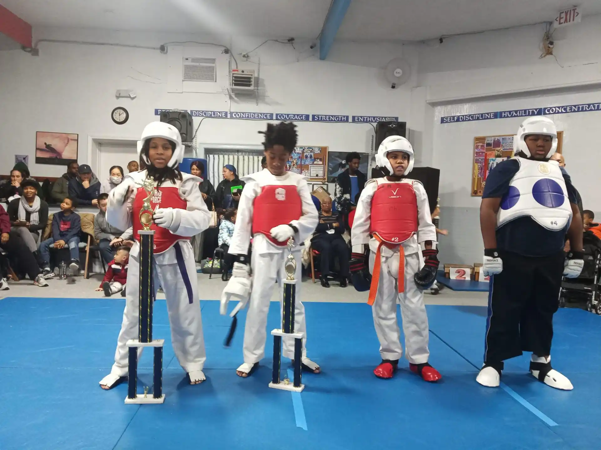 a group of people in white and red uniforms with swords in a room with a crowd