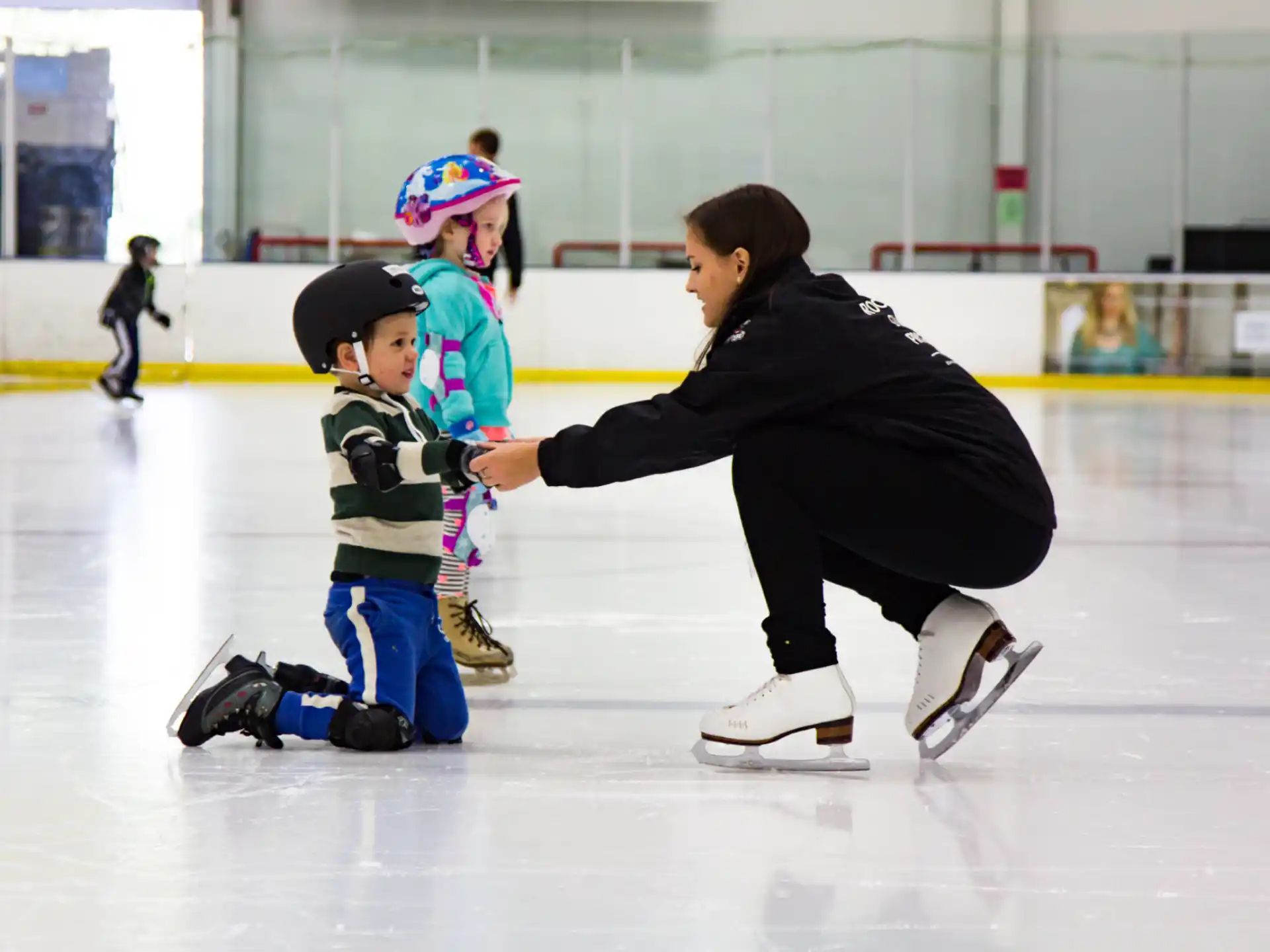 a man and two children on an ice rink