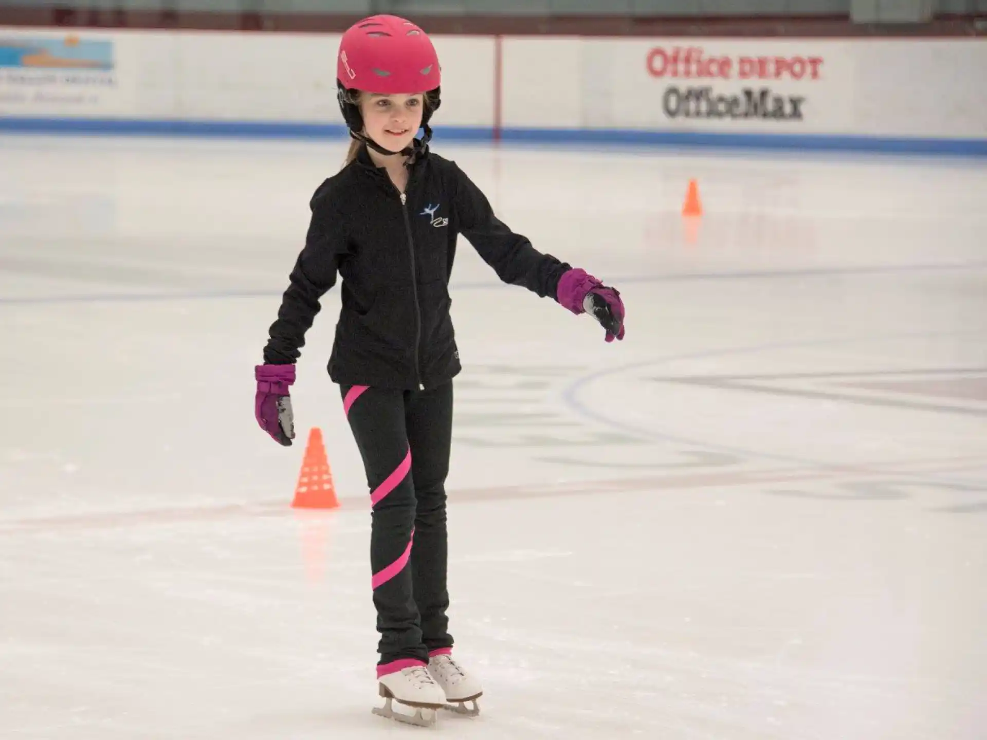 a girl wearing a helmet and ice skates