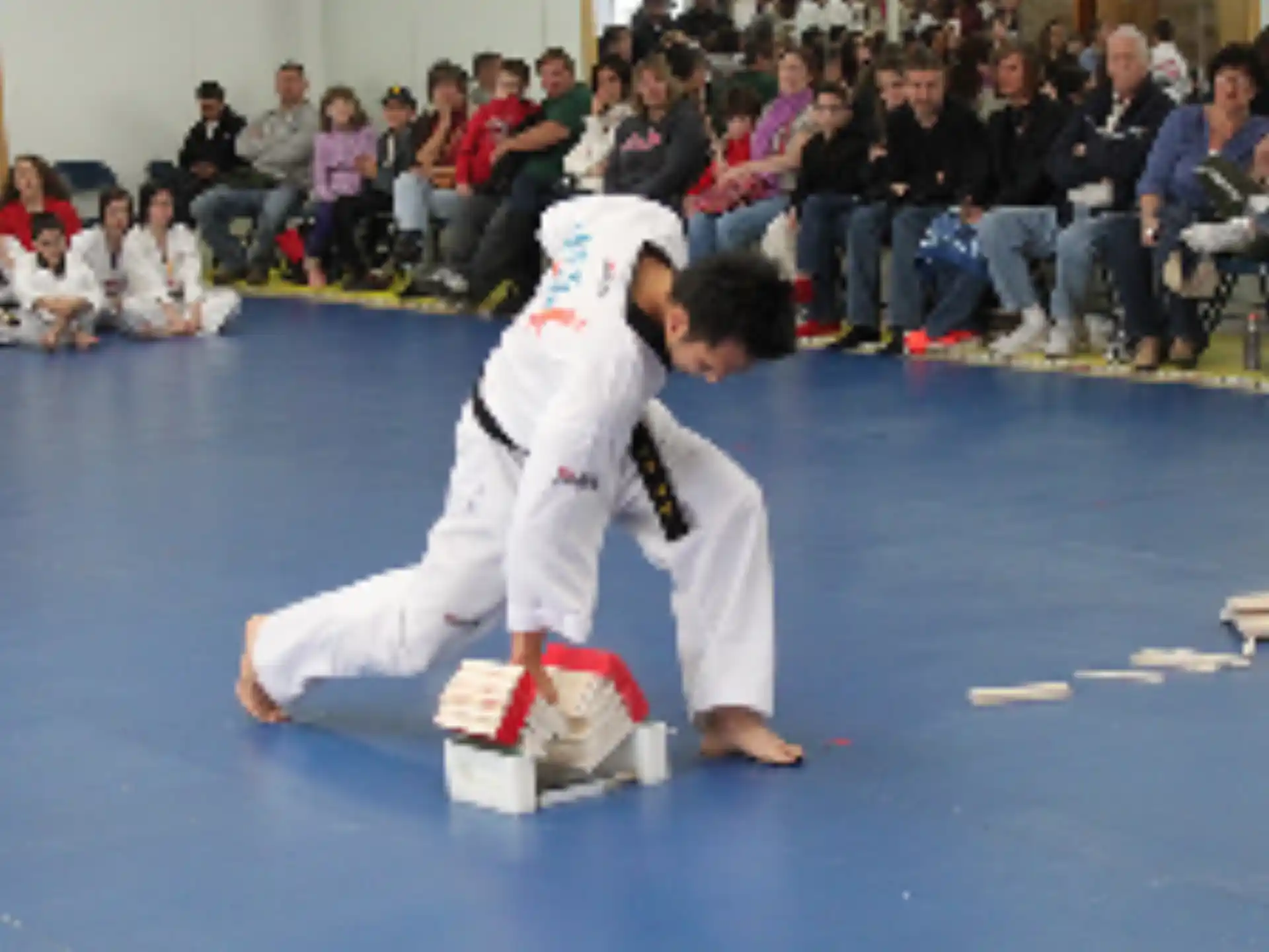a person in a karate uniform kicking another man in the face