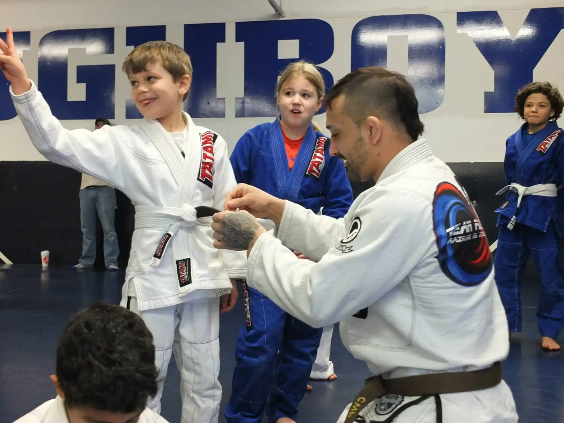 a man holding a trophy with a boy in a karate uniform