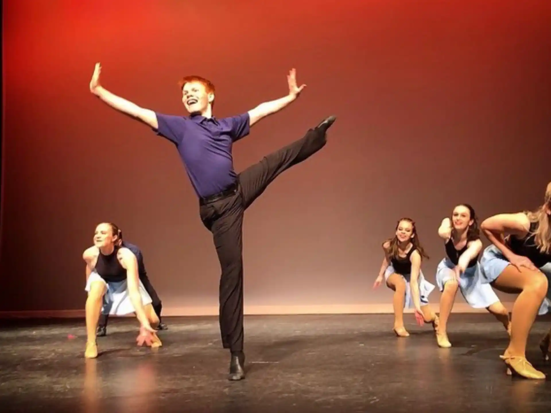 a person standing on the hands in front of a group of women