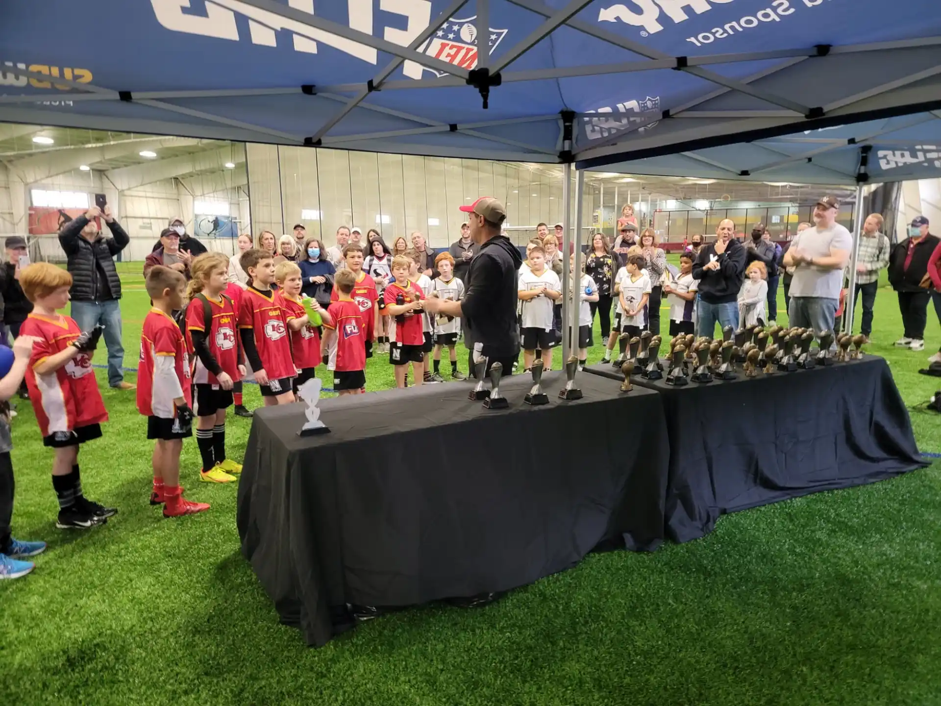 a group of children standing on a green mat in front of a crowd