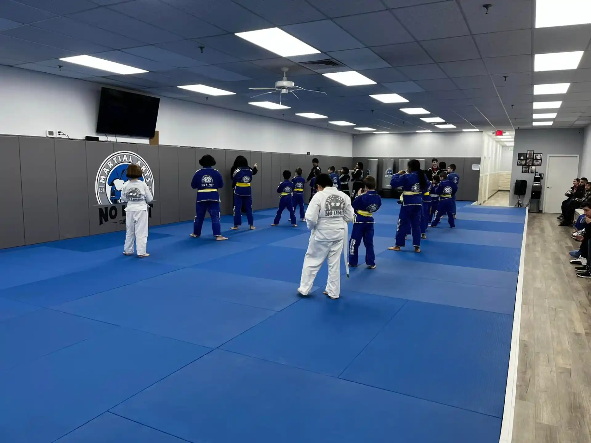 a group of people in white karate uniforms on a blue mat