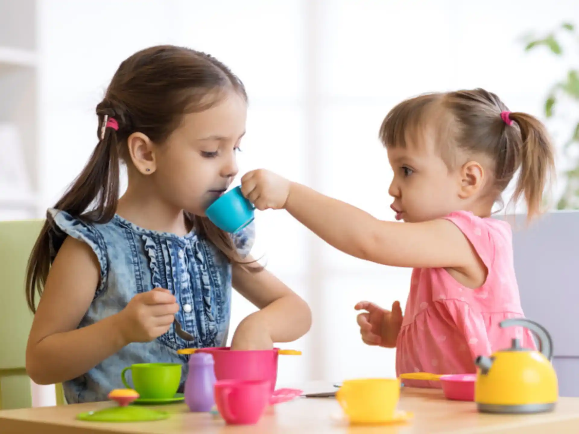 a couple of young girls drinking tea