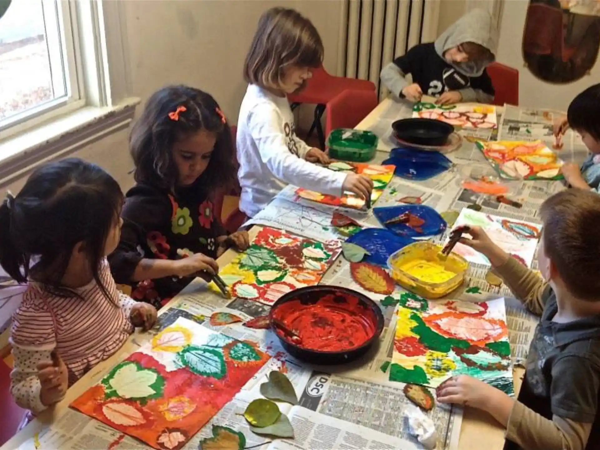 a group of children sitting around a table with food on it