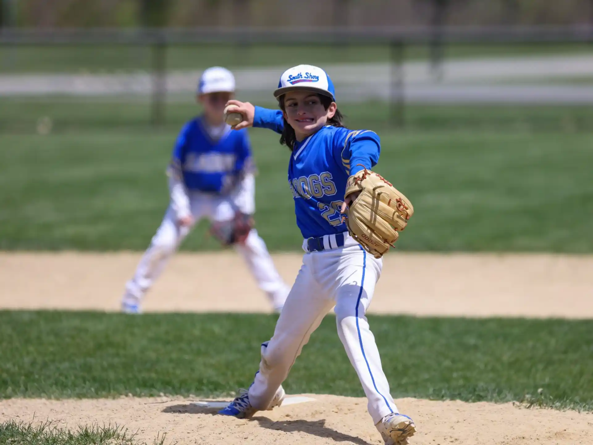 a young girl pitching a baseball