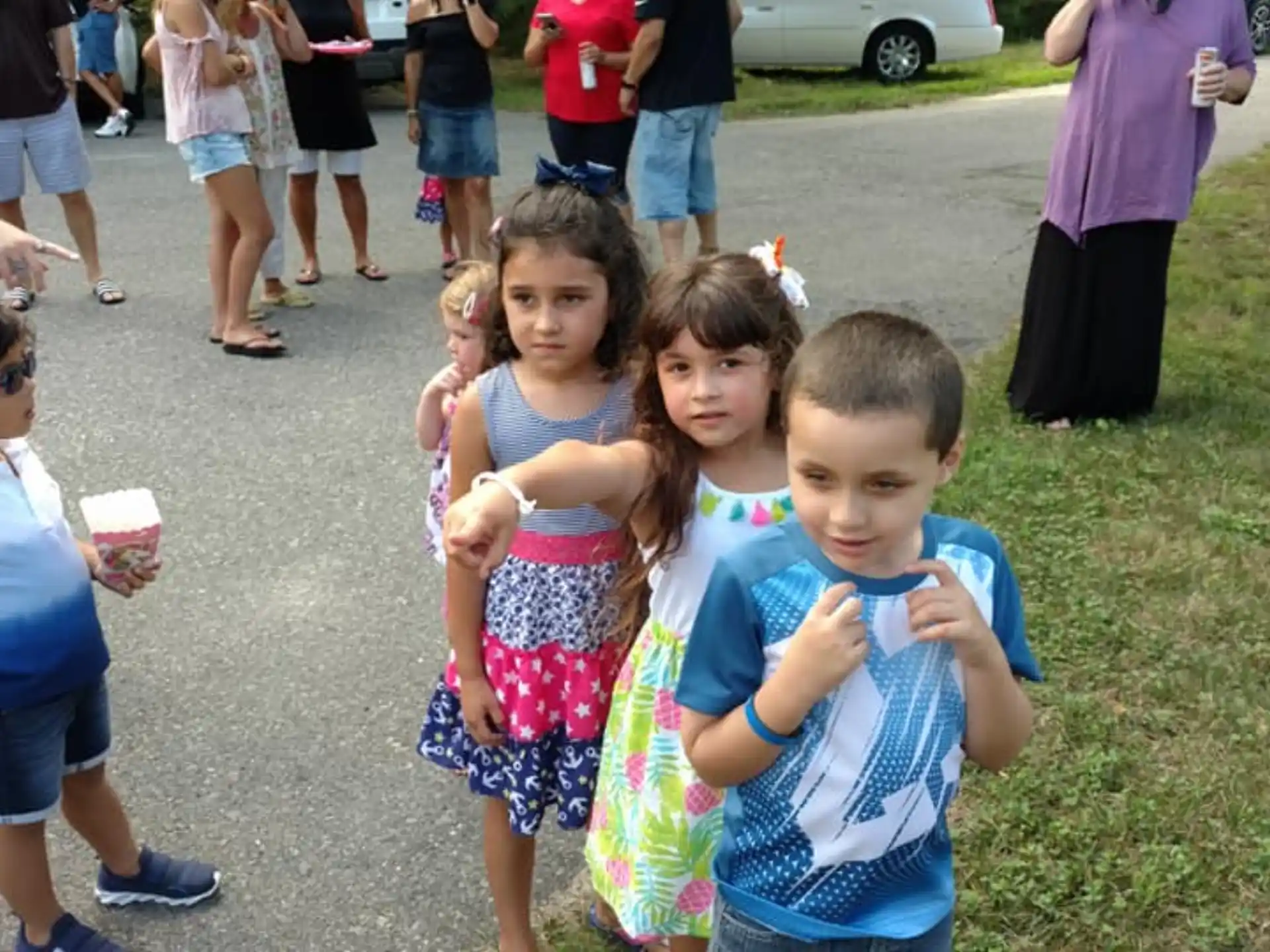 a group of children standing on a sidewalk