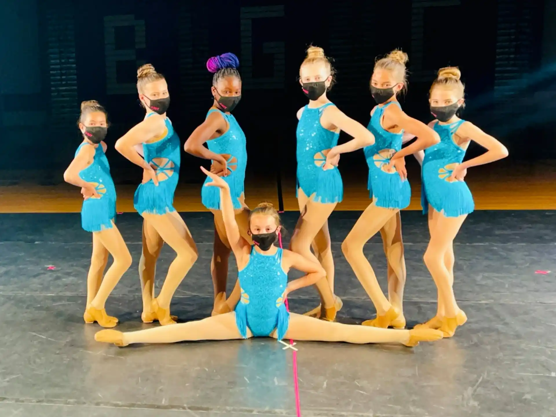 a group of girls in blue dresses