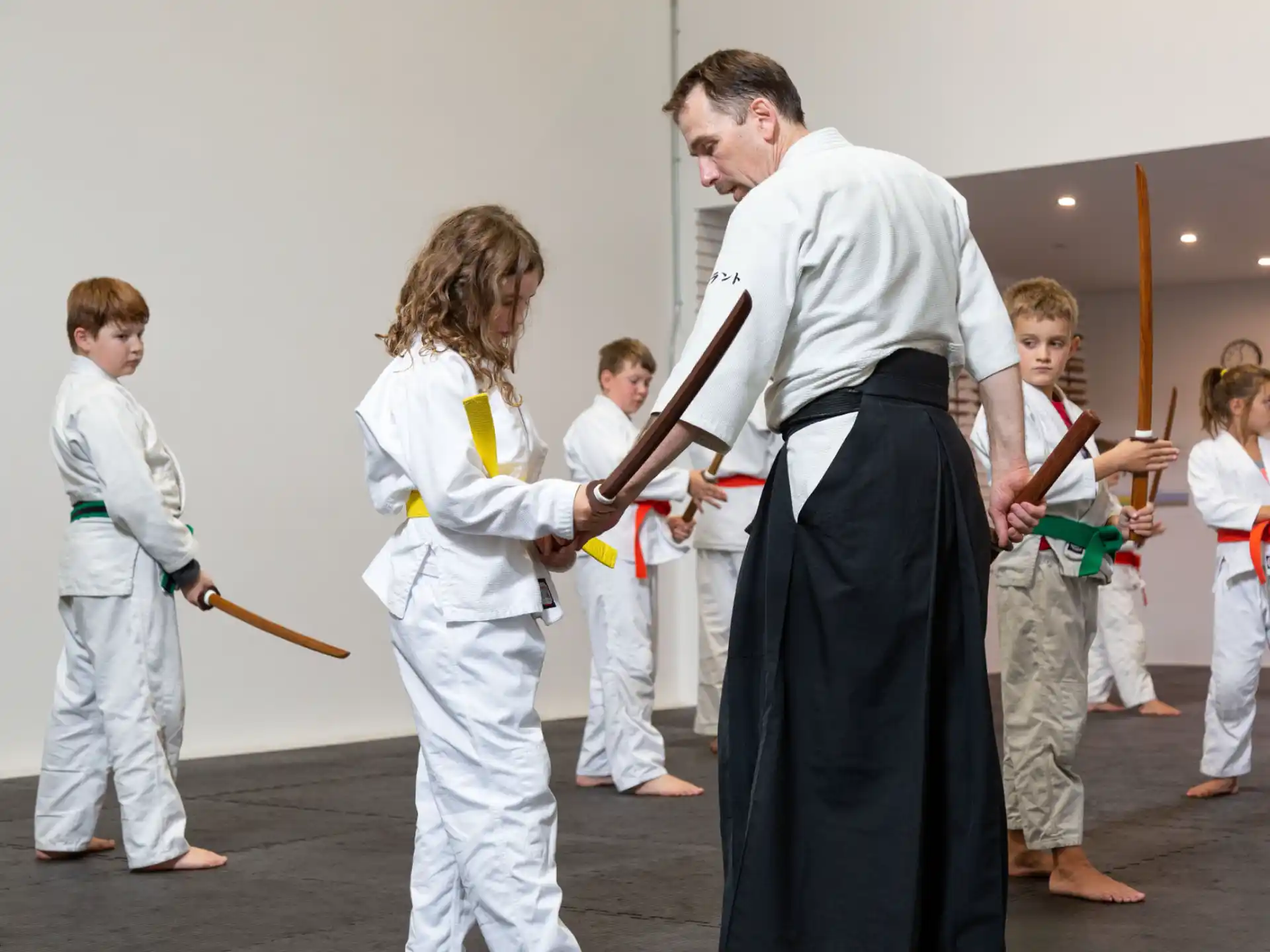 a man and a woman in karate uniforms with a girl in a white uniform