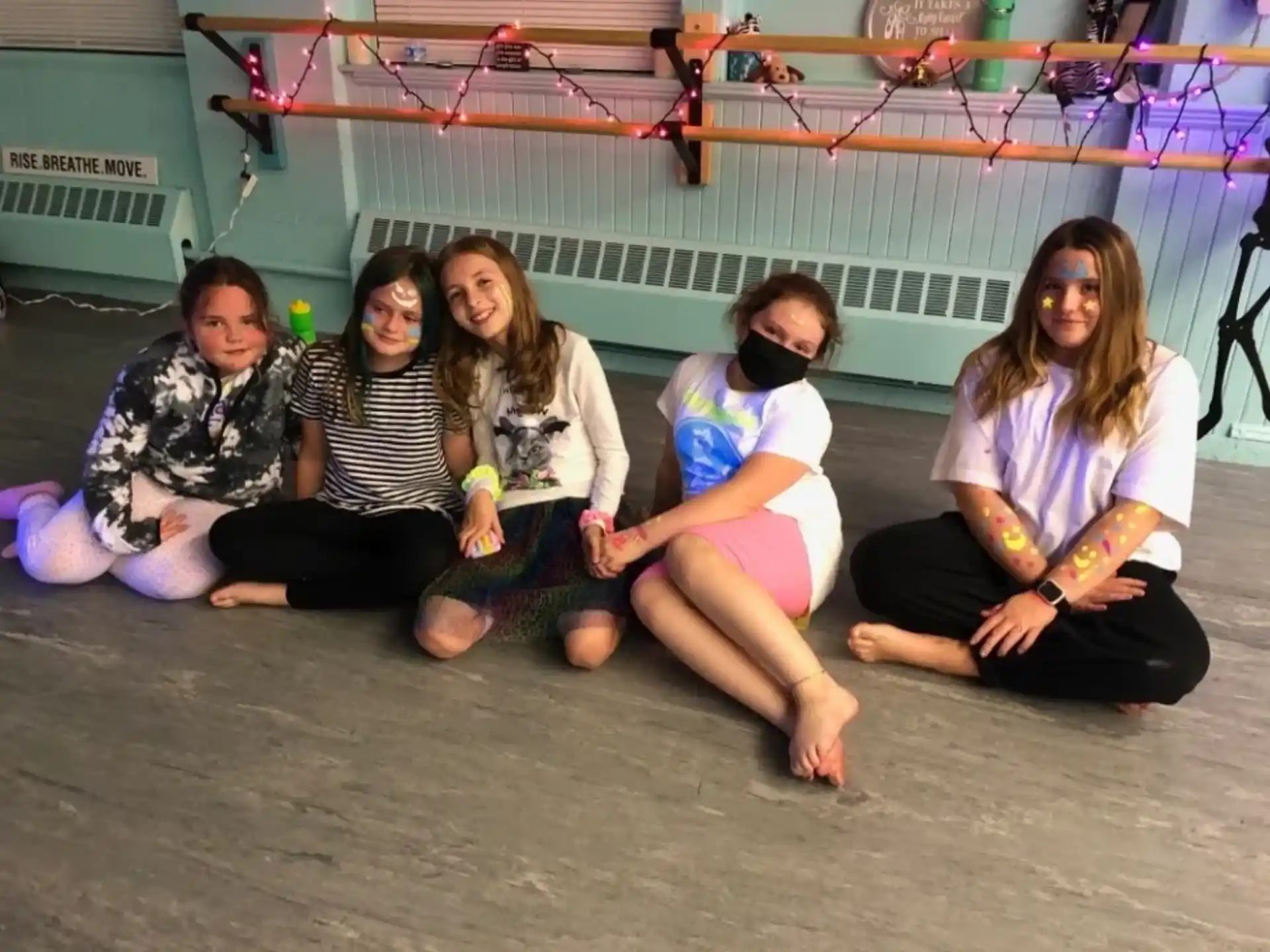 a group of people sitting on the ground posing for the camera