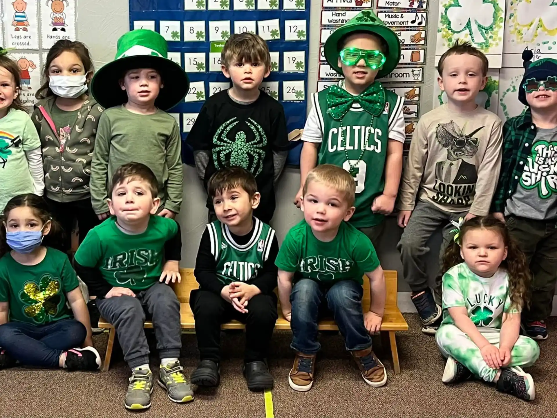a group of children wearing green and black clothing