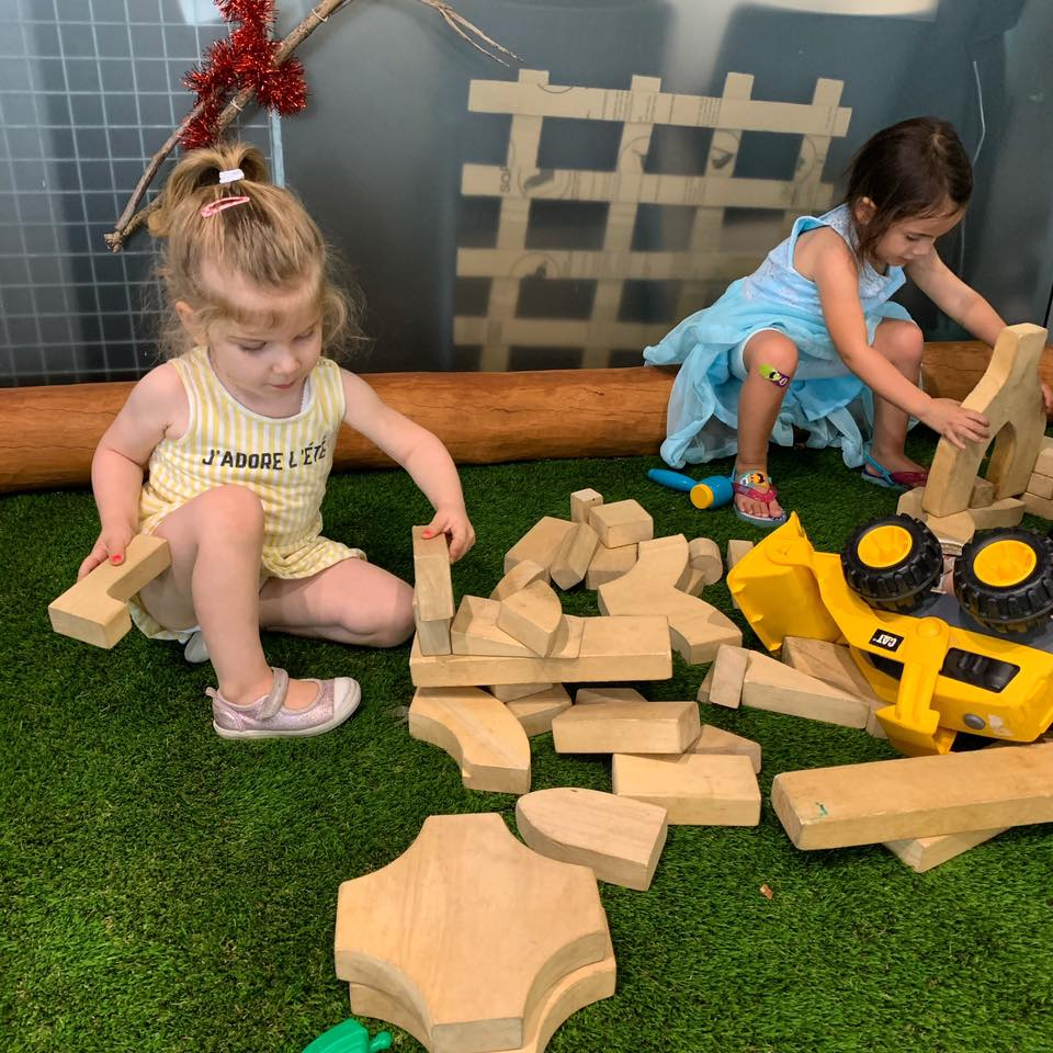 a couple of girls playing with blocks