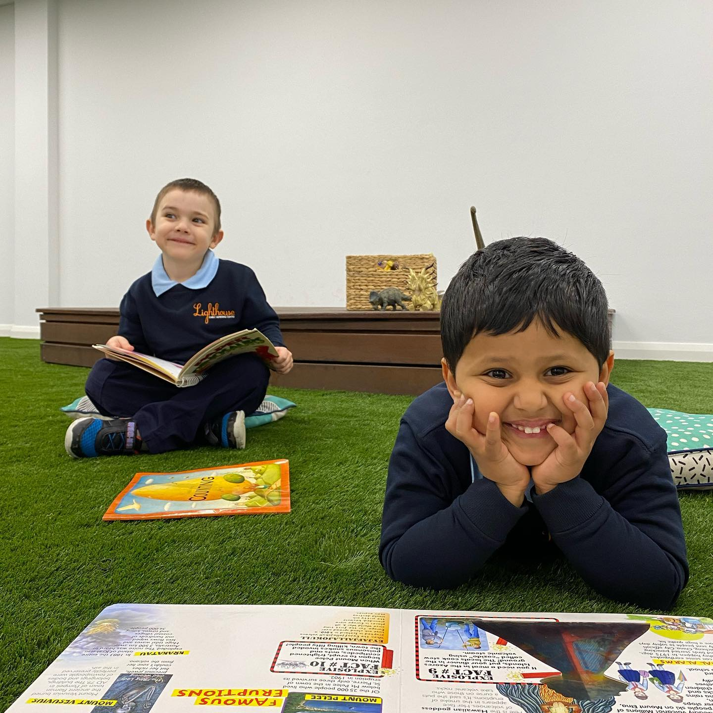 a couple of boys sitting on the floor reading books