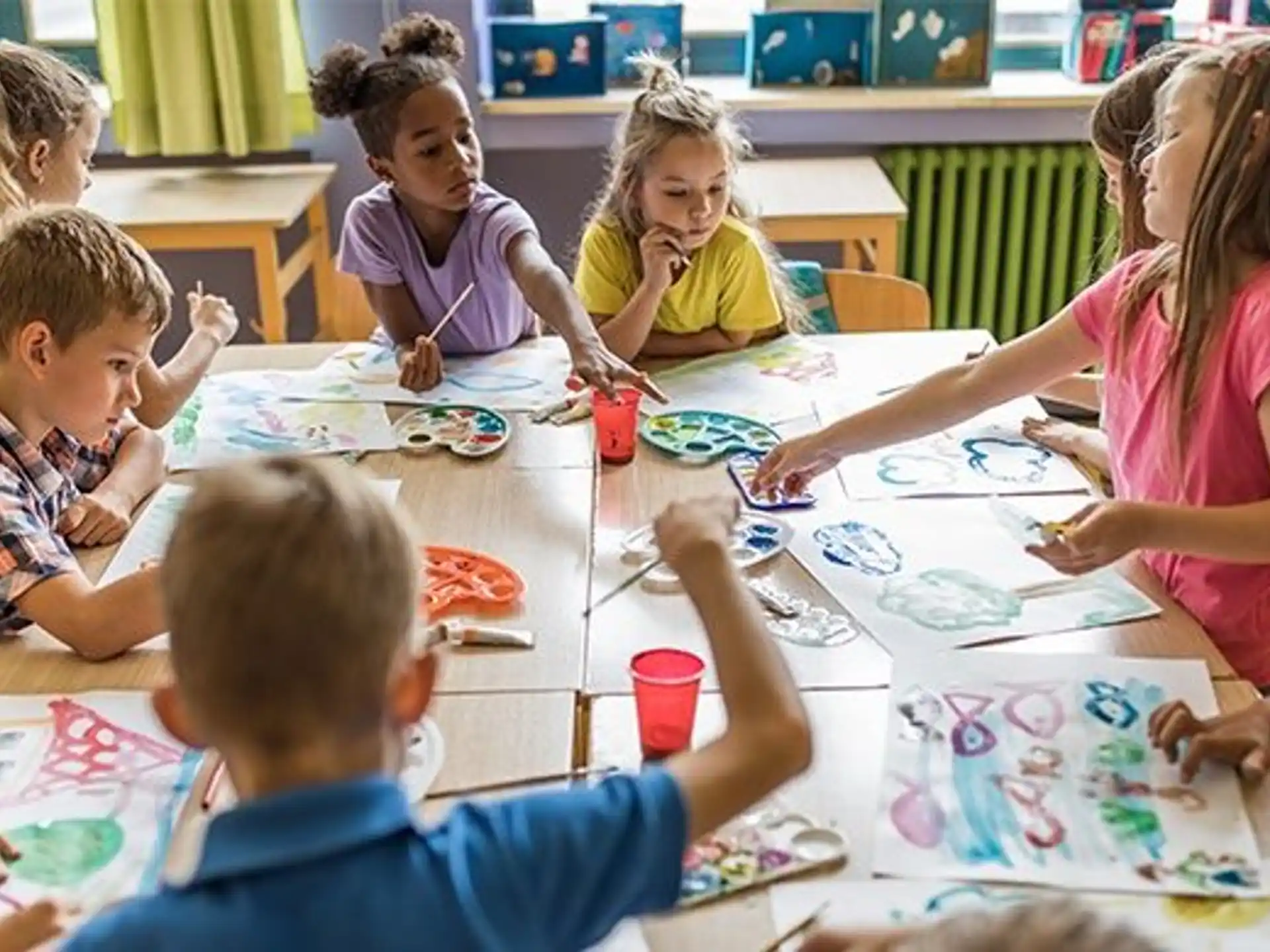 a group of children sitting around a table