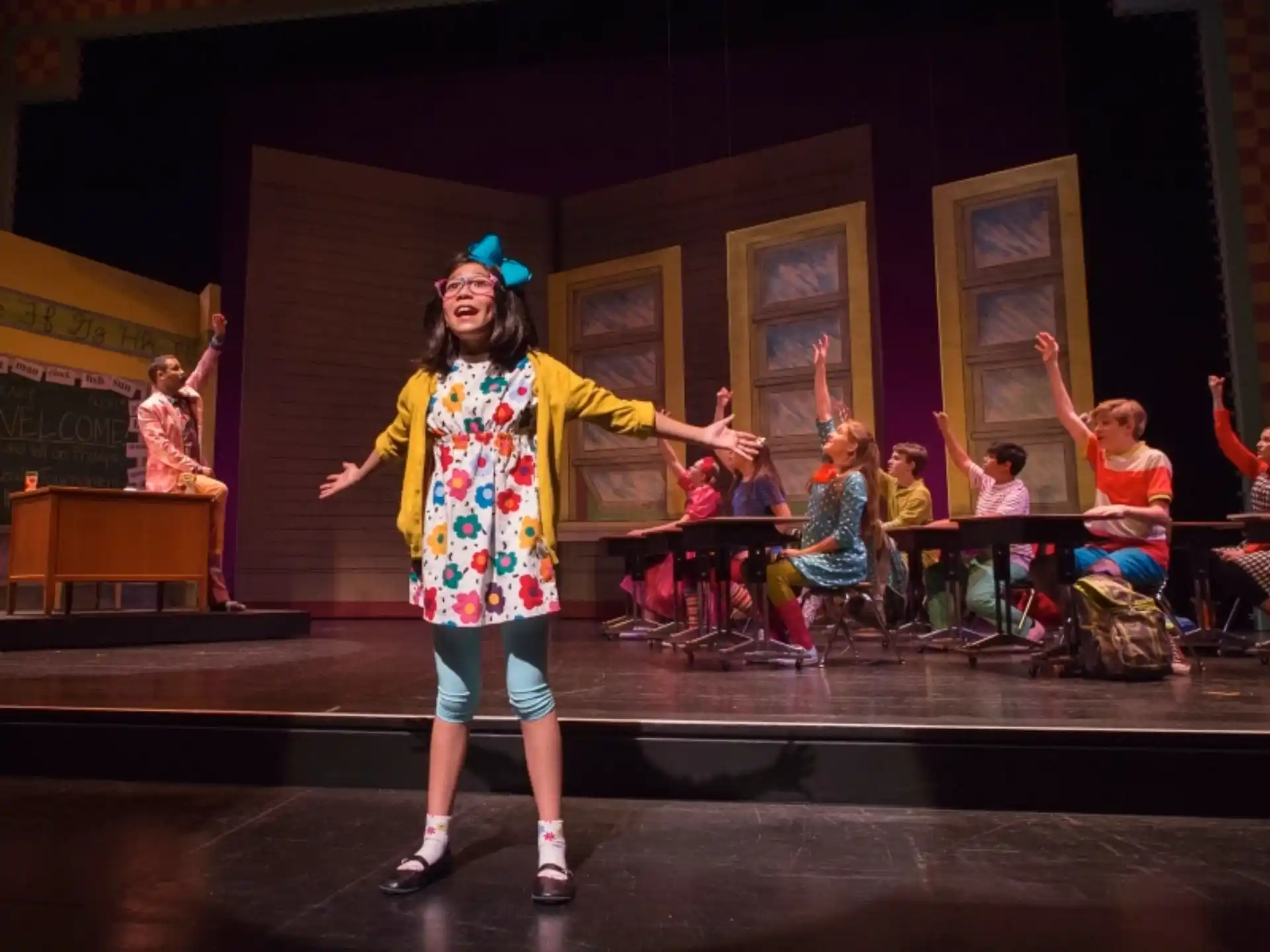 a person on stage with a group of people in the back