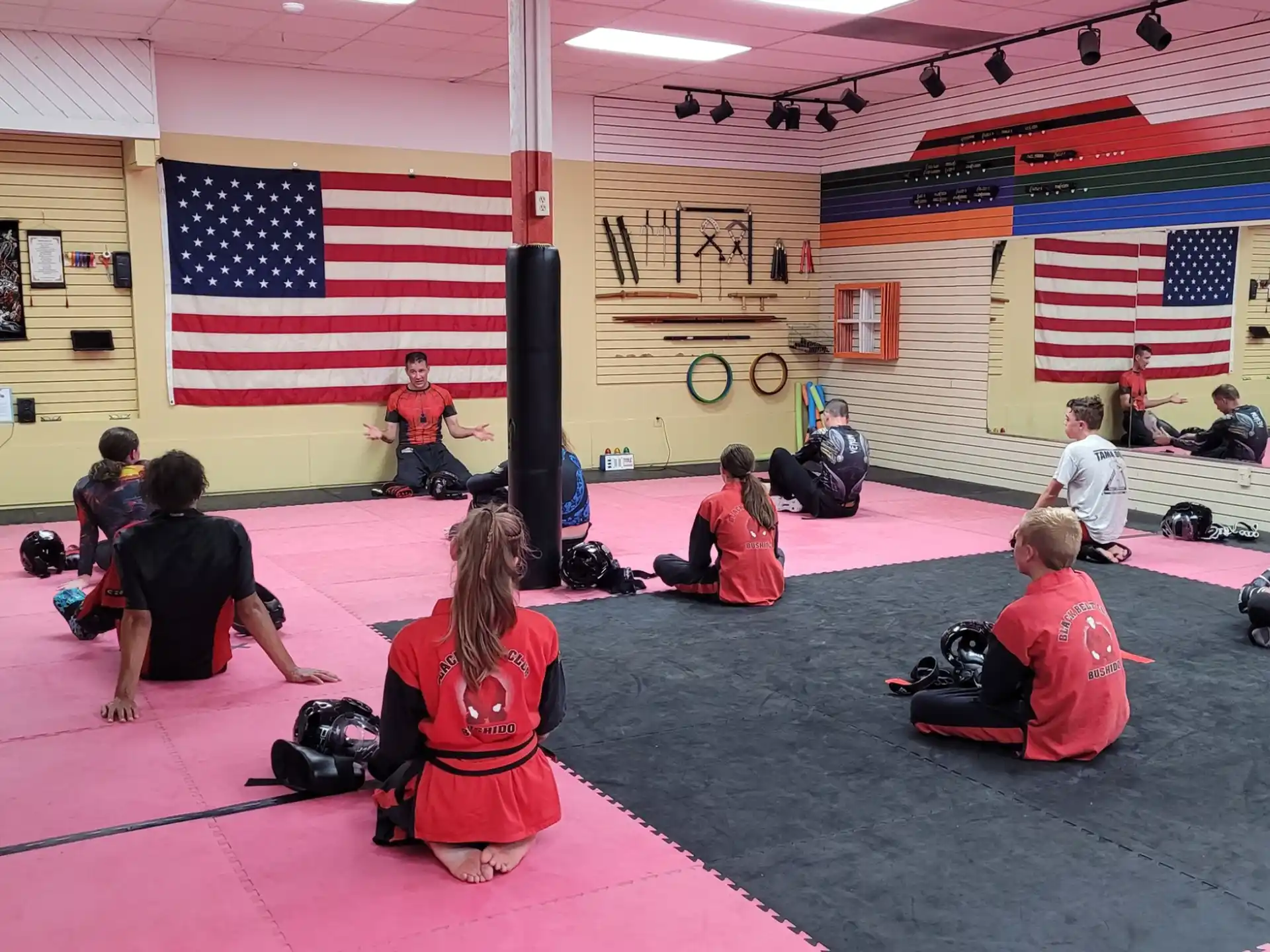 a group of people sitting in a room with a flag