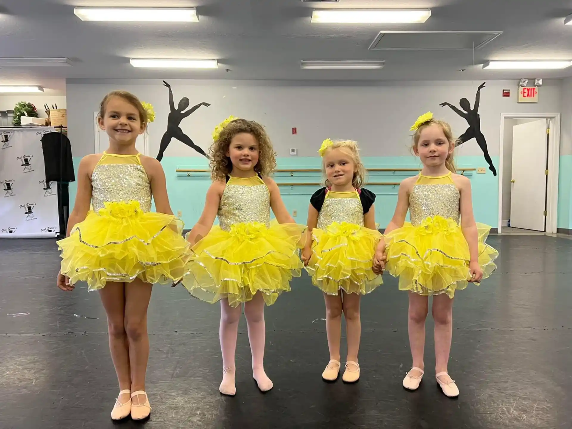 a group of girls in yellow dresses