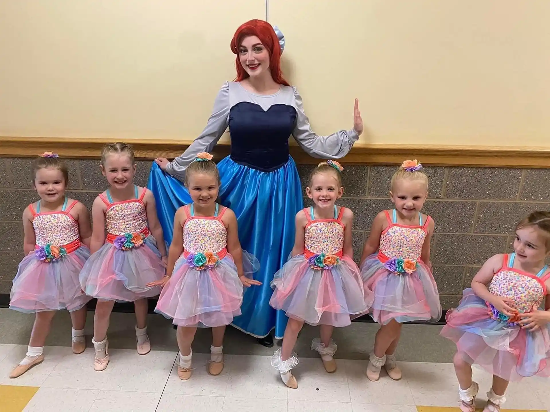 a person in a blue dress with a group of girls in dresses