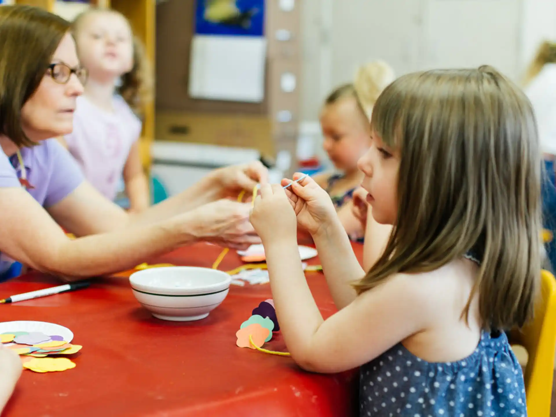 a group of children sitting at a table eating food