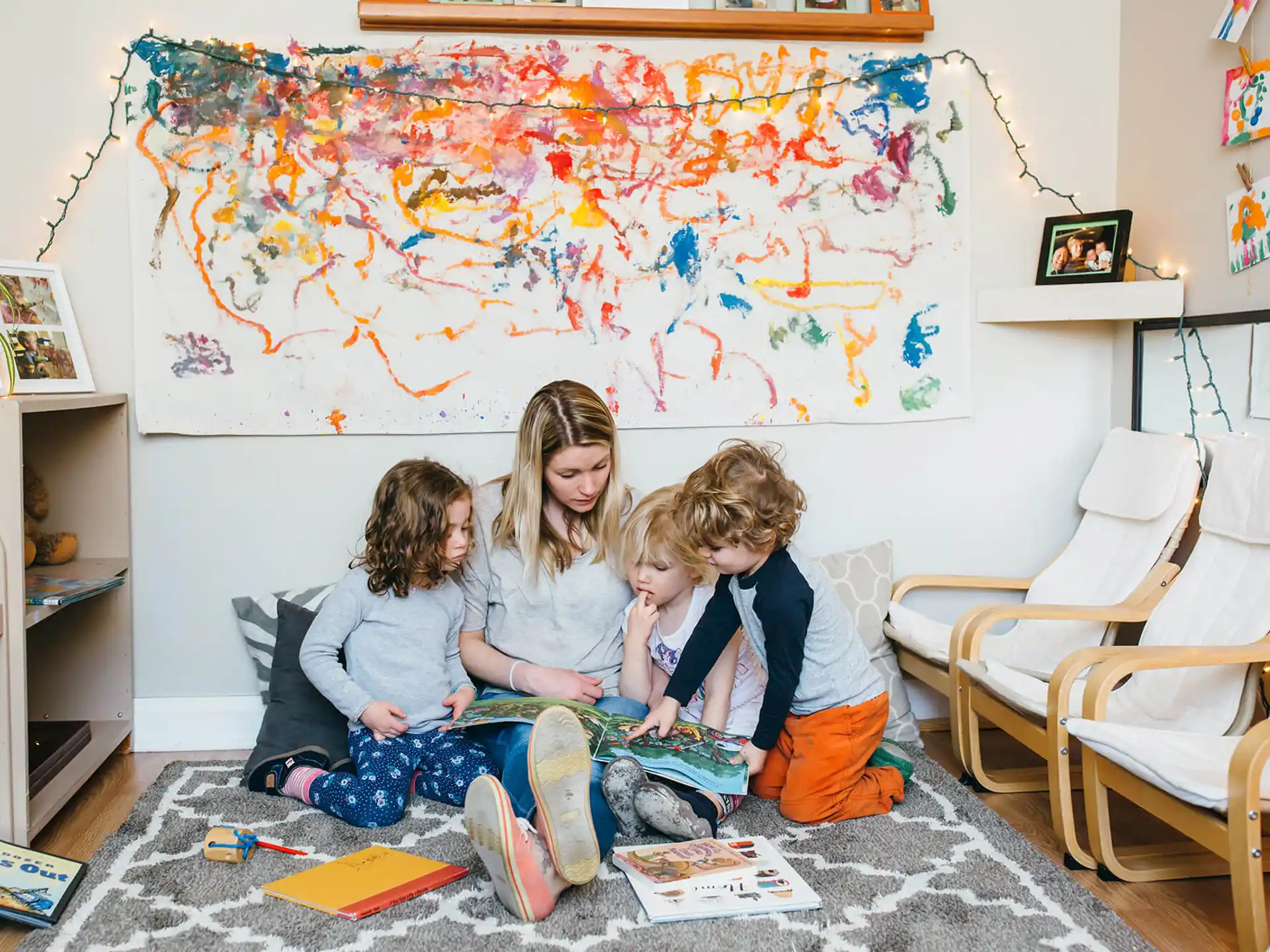 a group of children sitting on the floor in a room with a map