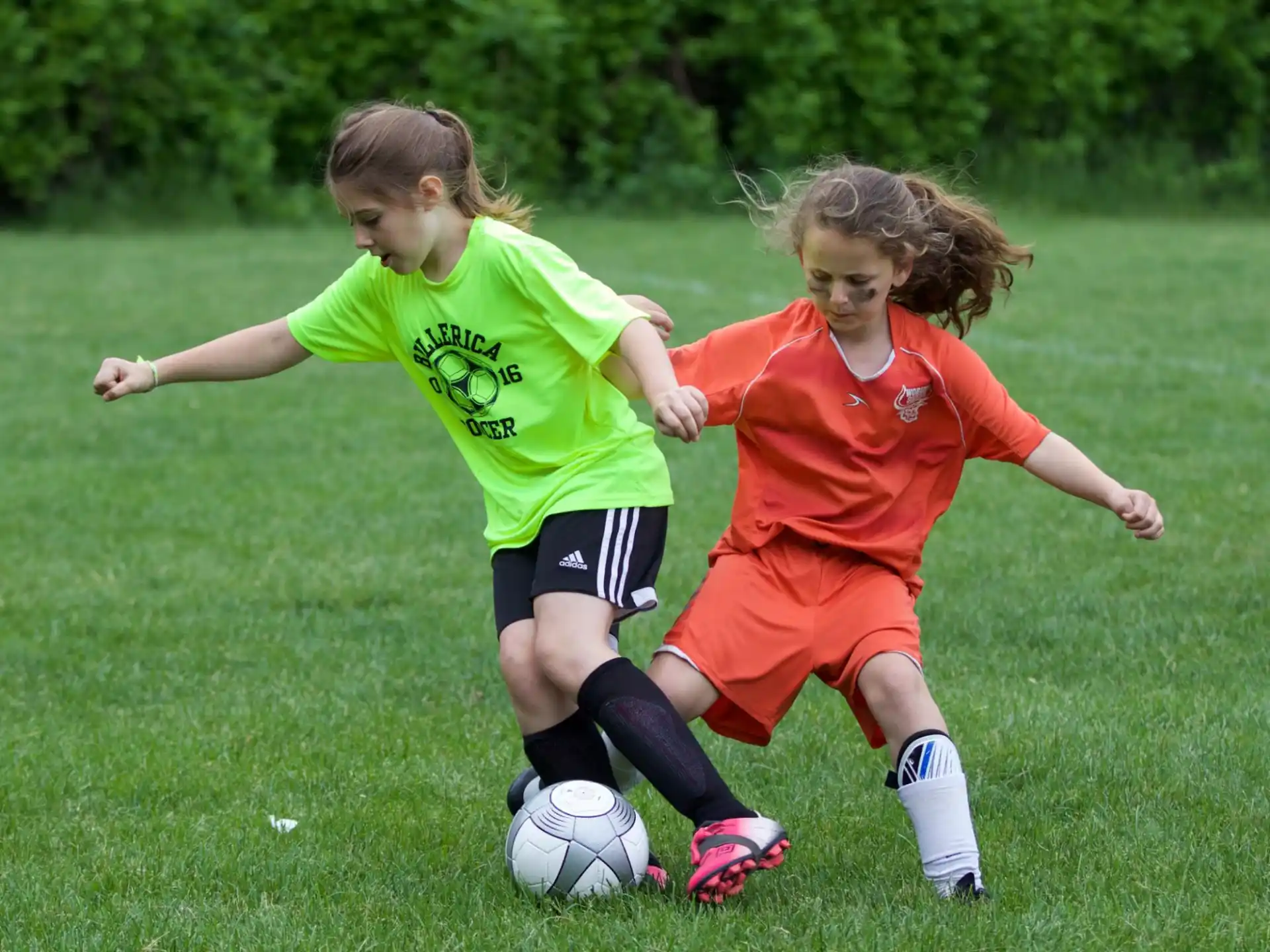 girls playing football on a field