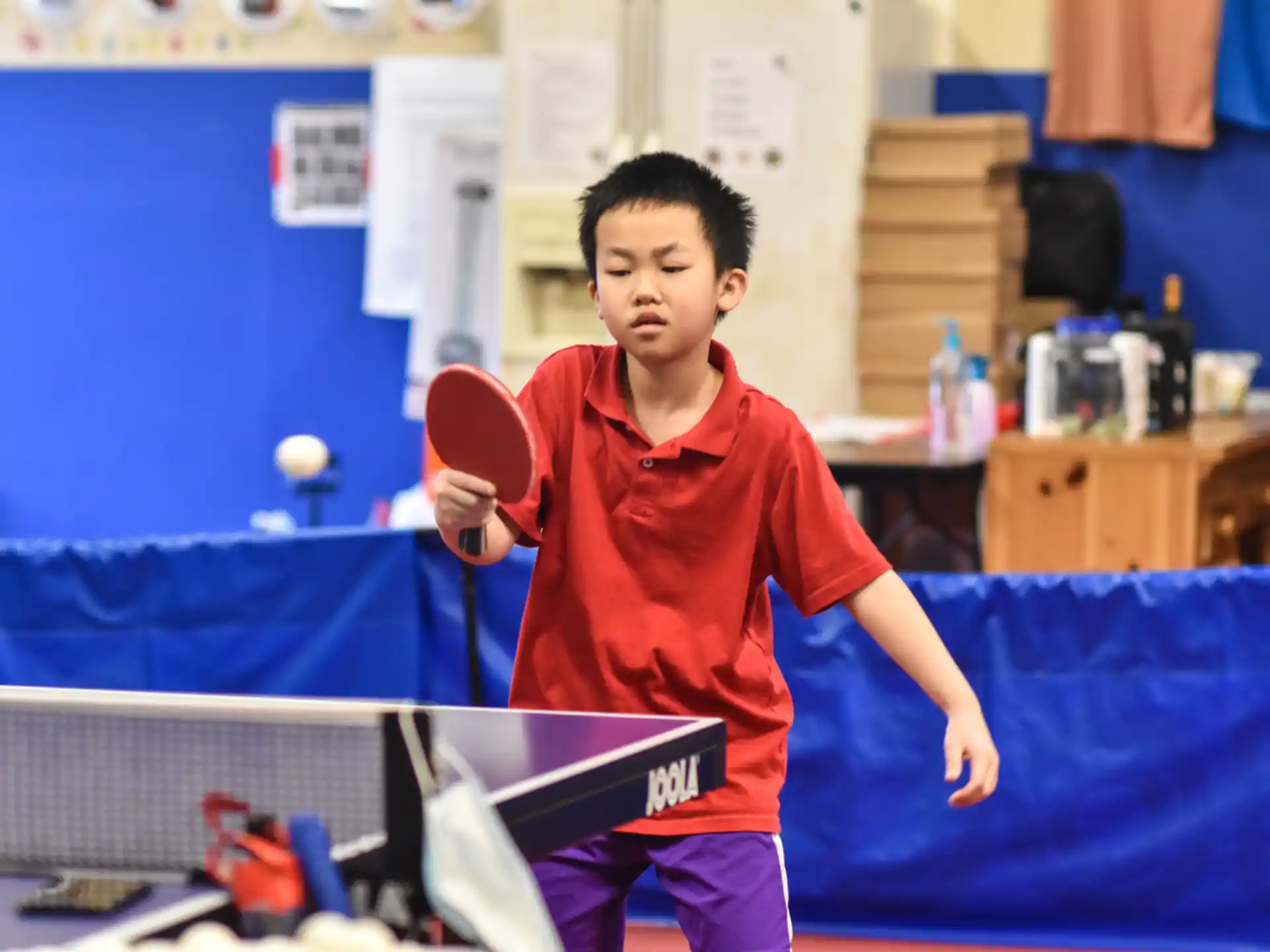 a boy holding a ping pong paddle