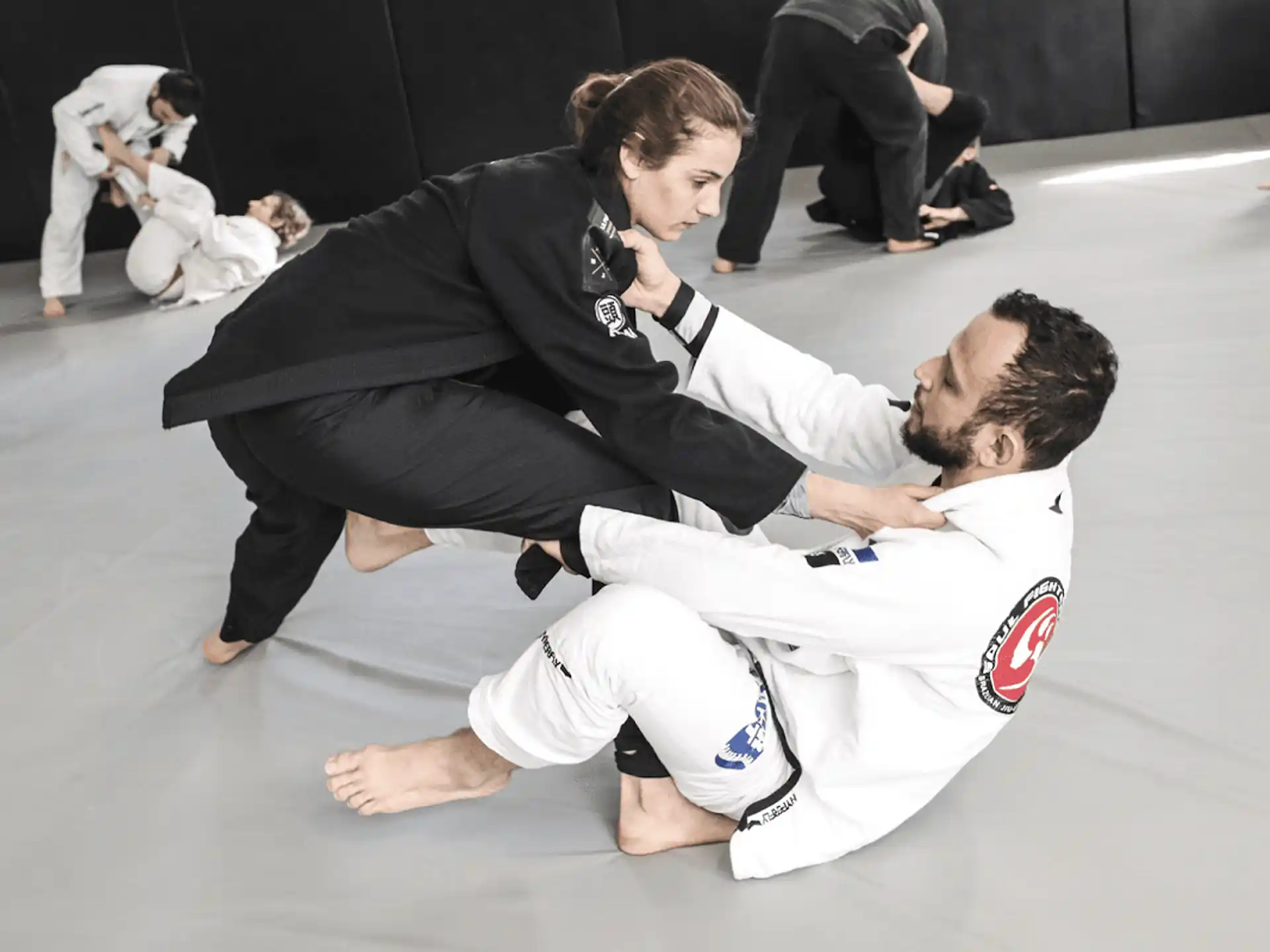 a man and a woman in karate uniforms on the floor