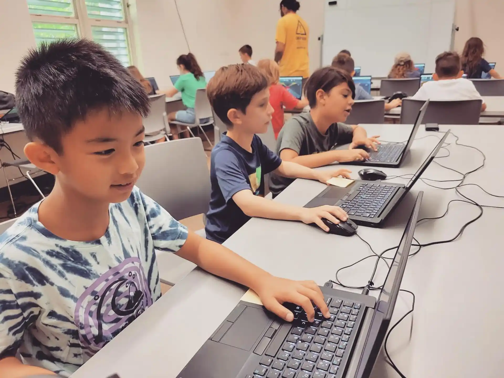 a group of children using laptops