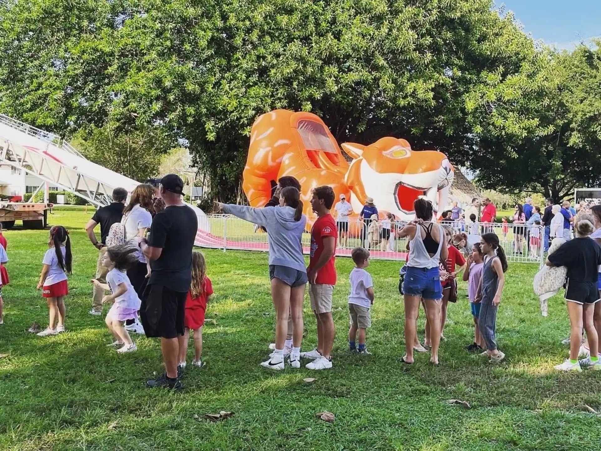 a group of people standing around a large orange object