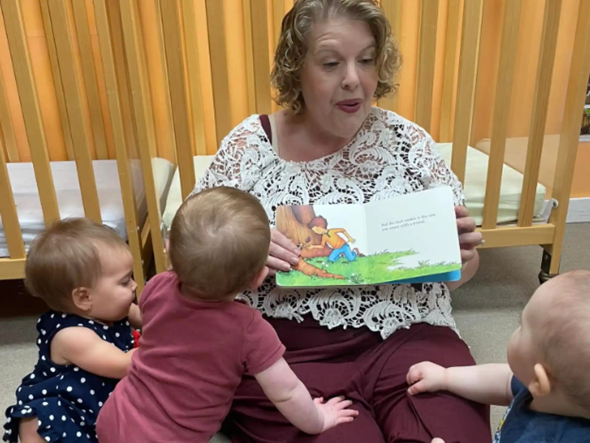 a person reading a book to several children