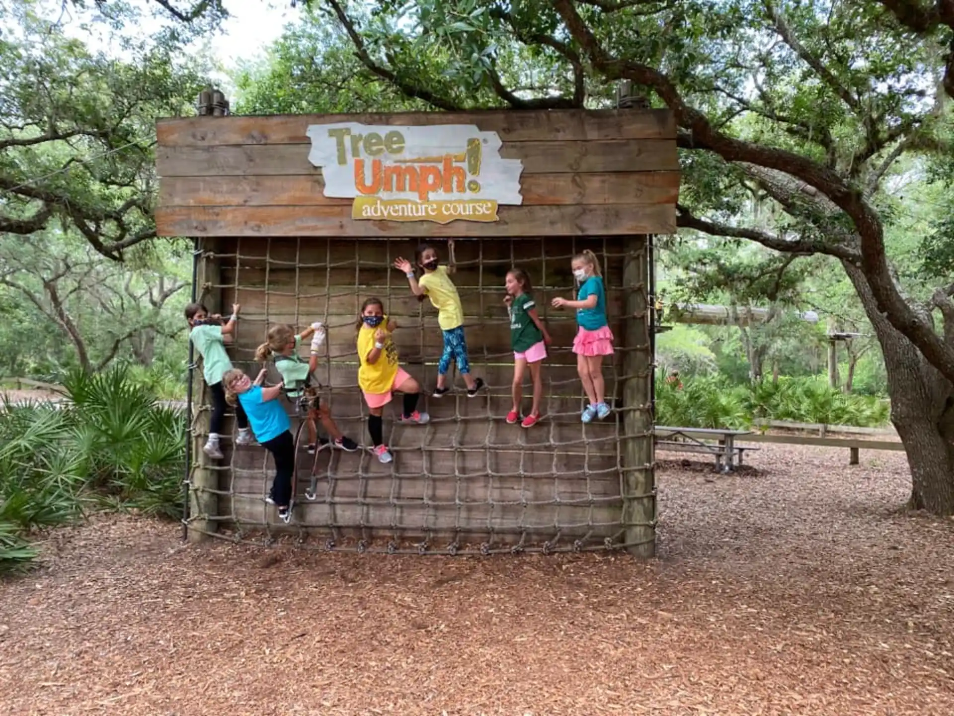 a group of kids jumping in the air in front of a sign