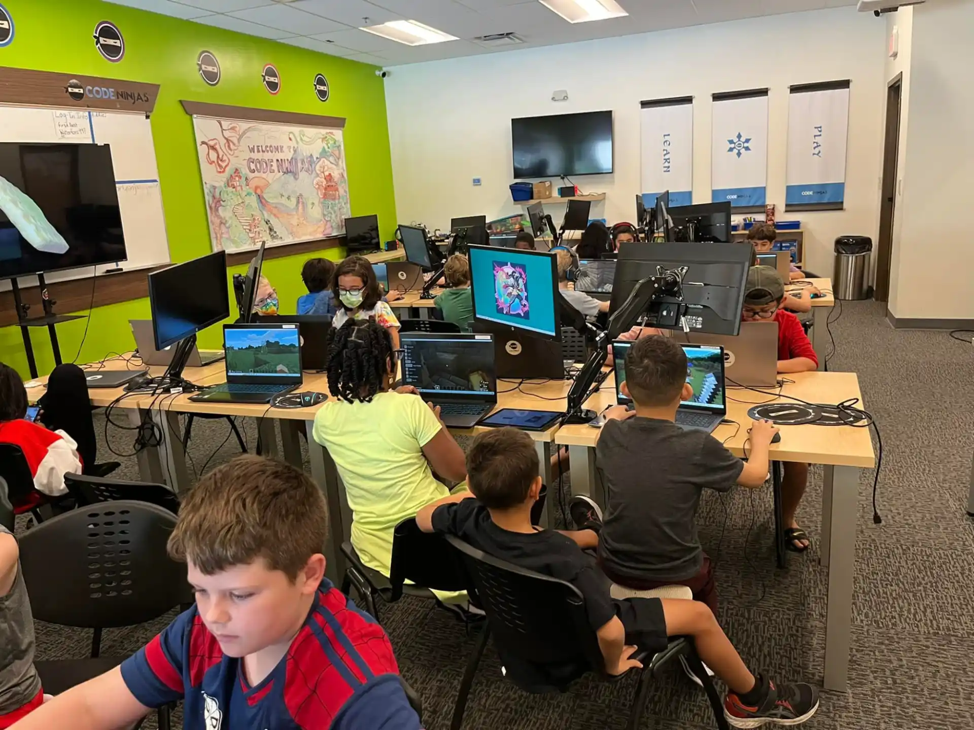 a group of people sitting at desks with computers