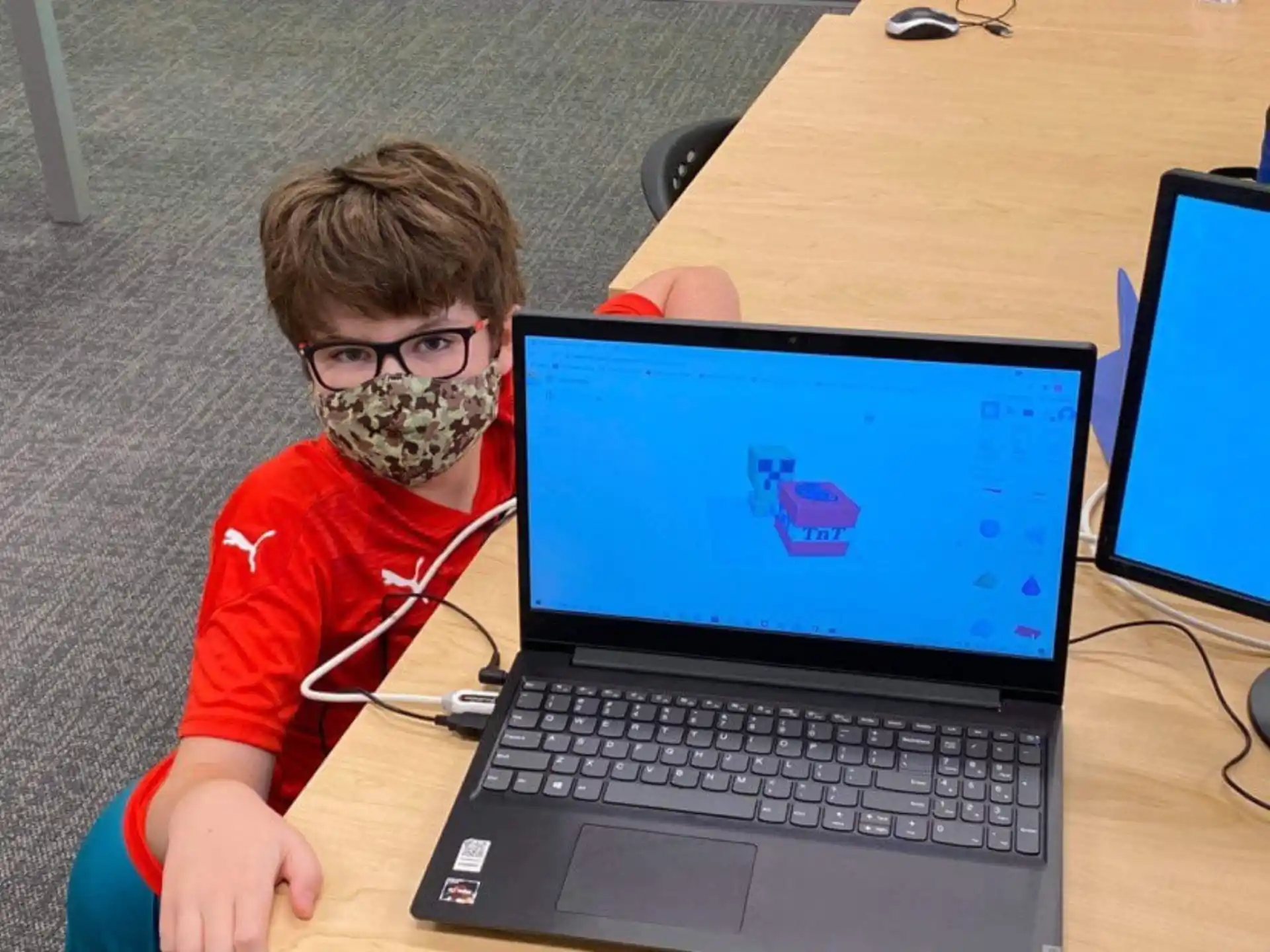 a boy wearing a mask and using a laptop