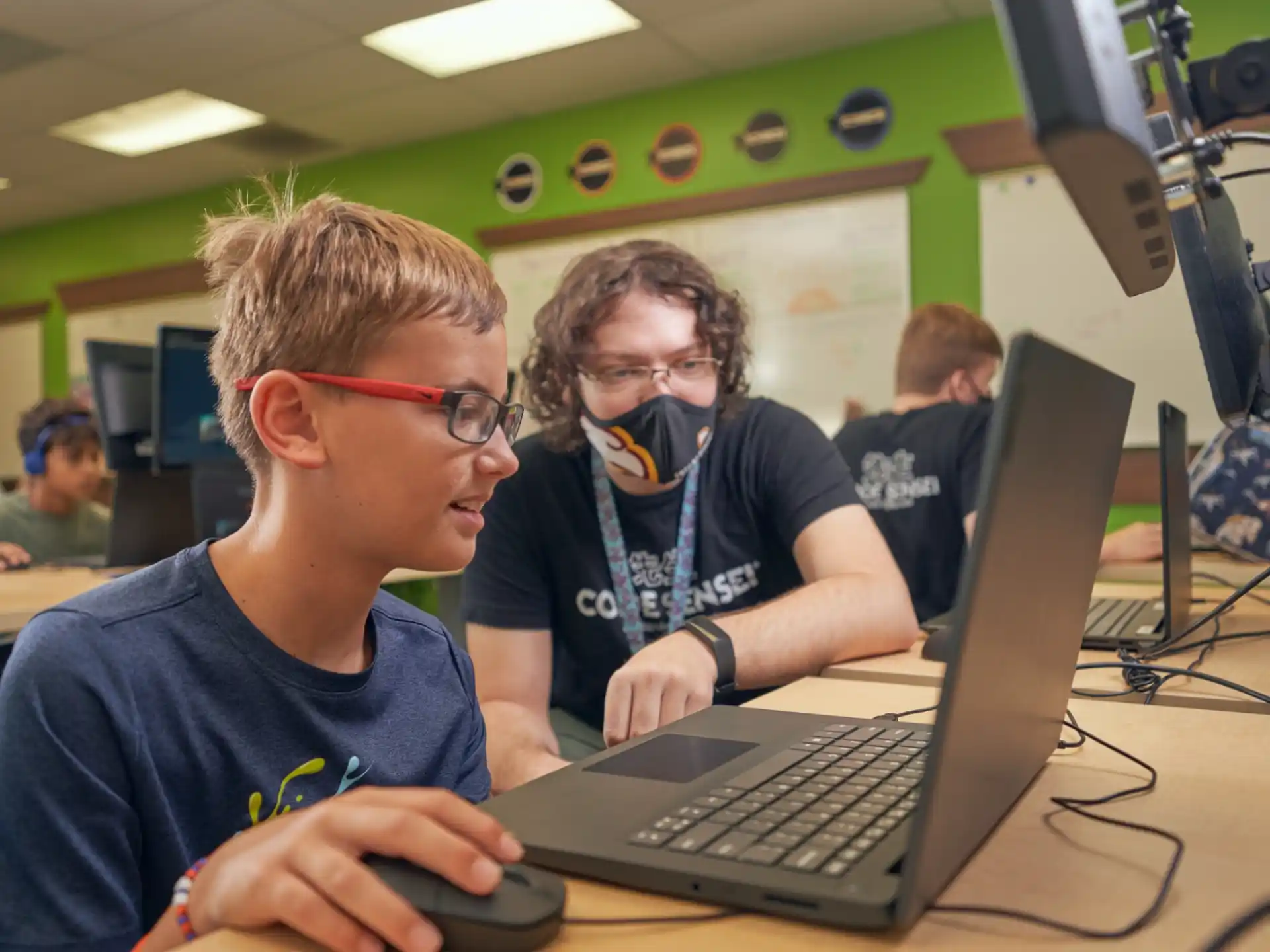 a couple of men using a laptop