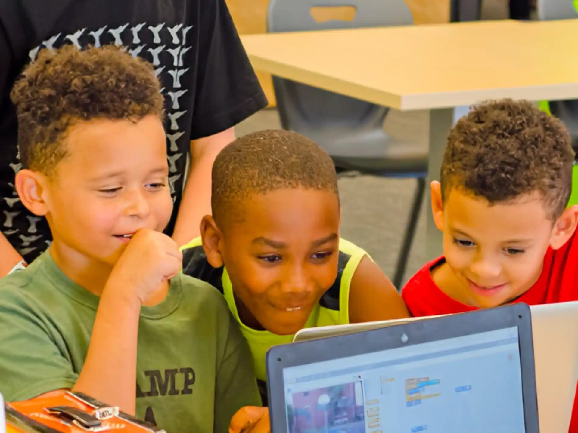a group of boys looking at a laptop