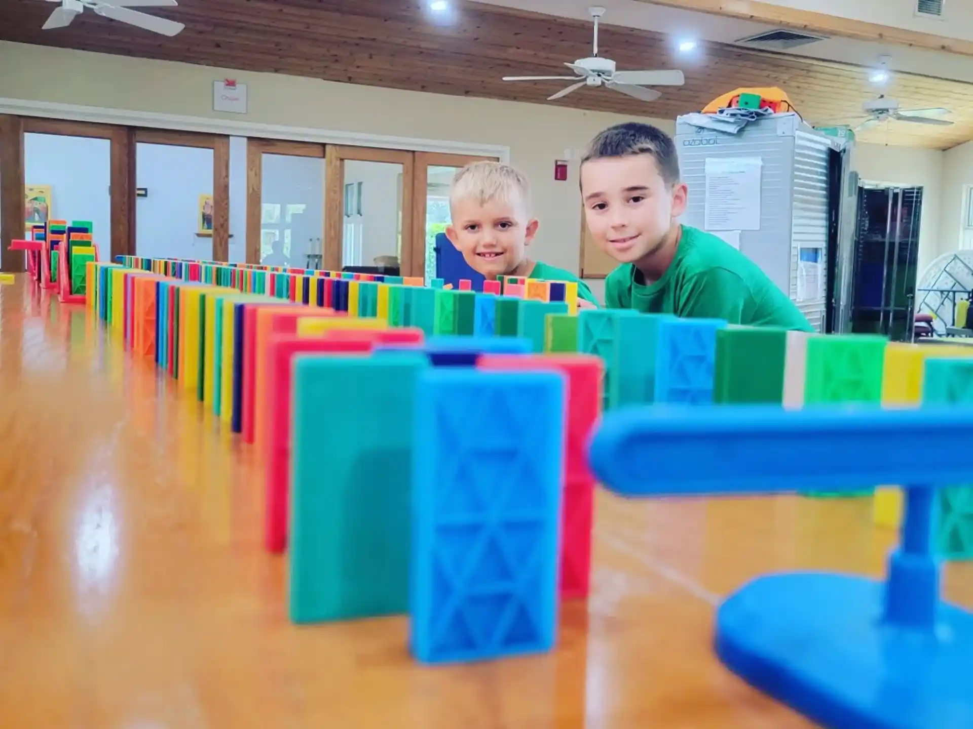 a group of boys sitting at a table with colorful blocks