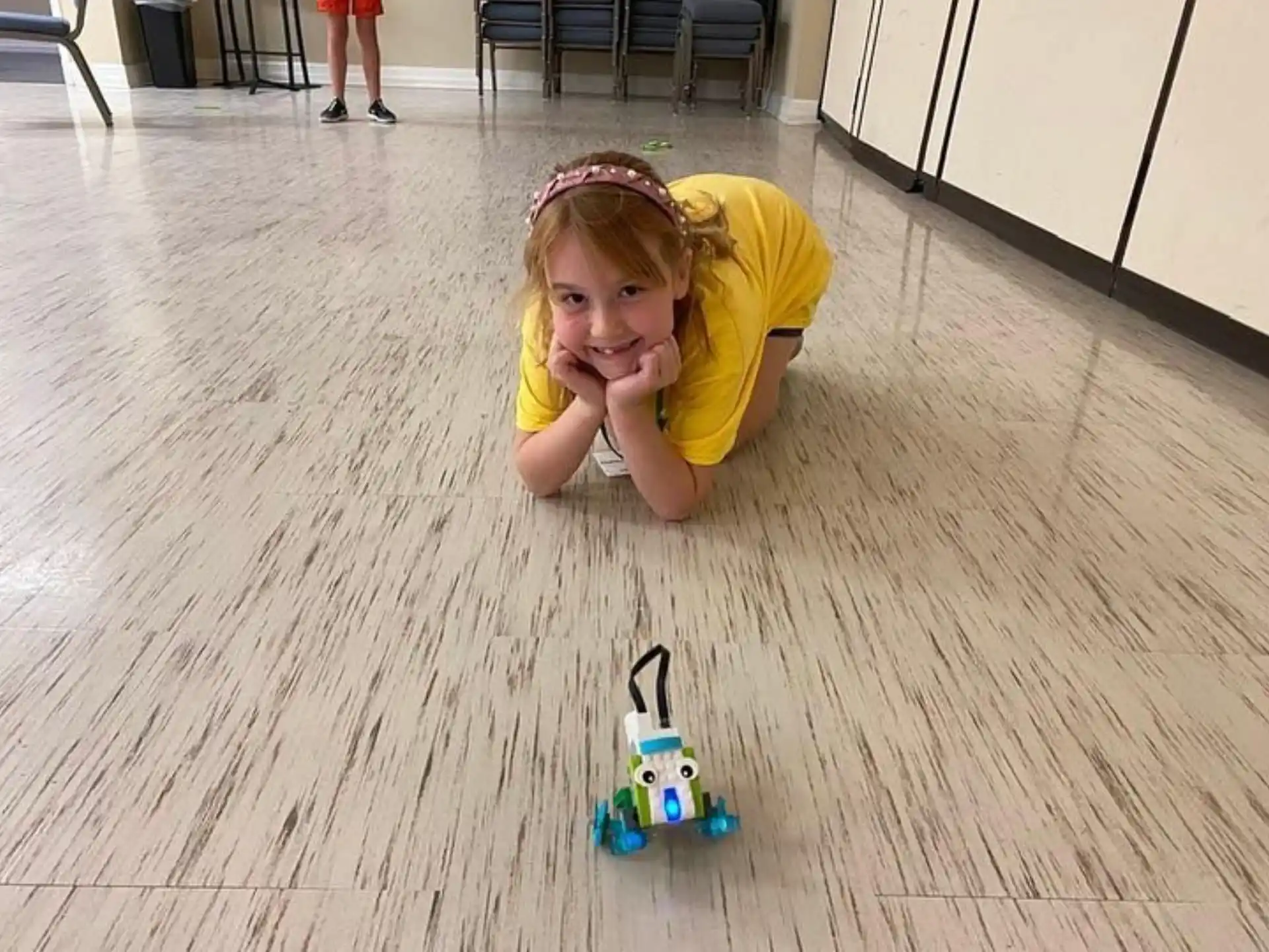a girl lying on the floor with a toy car