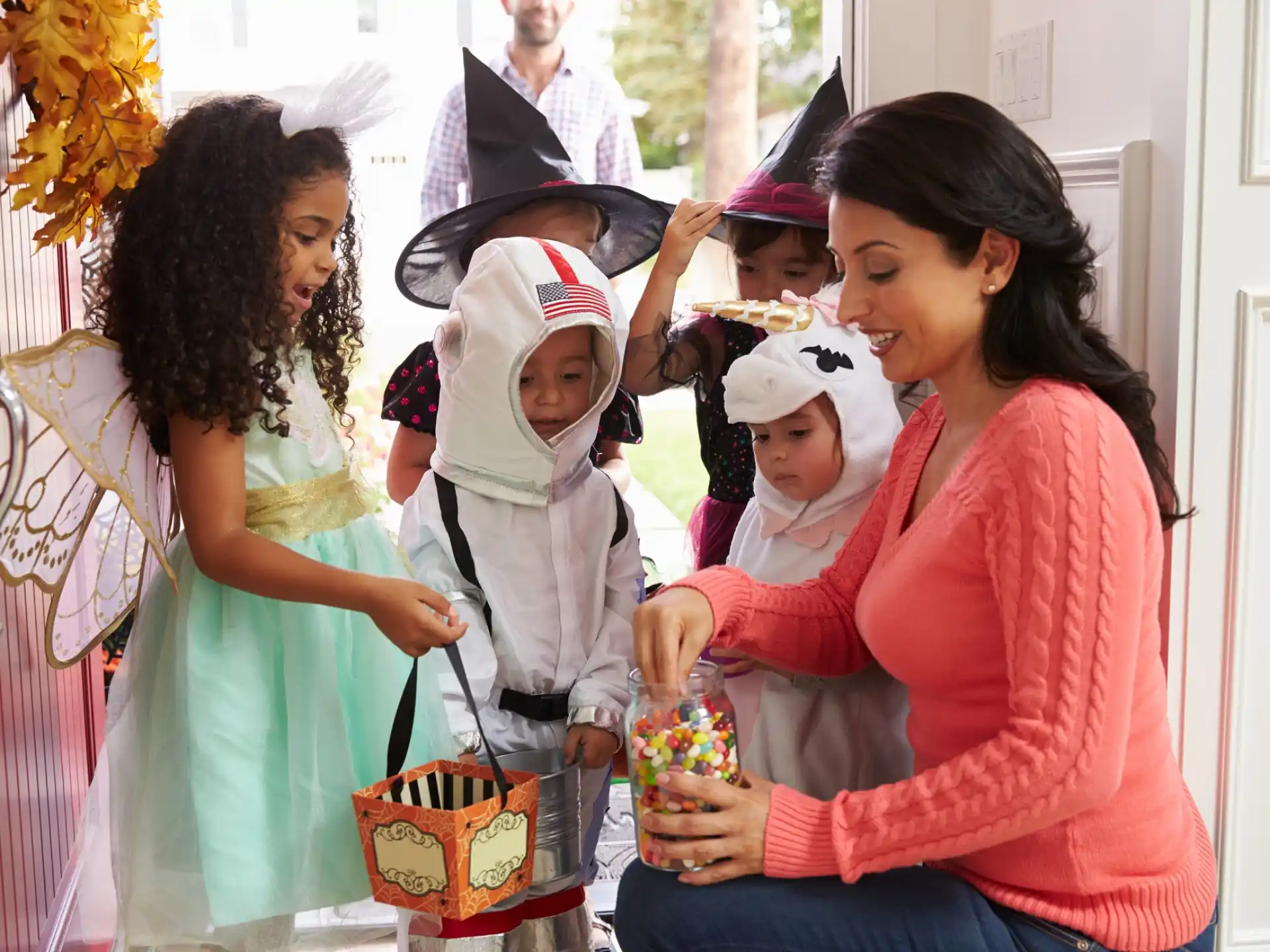 a person holding a baby with a group of people in clothing