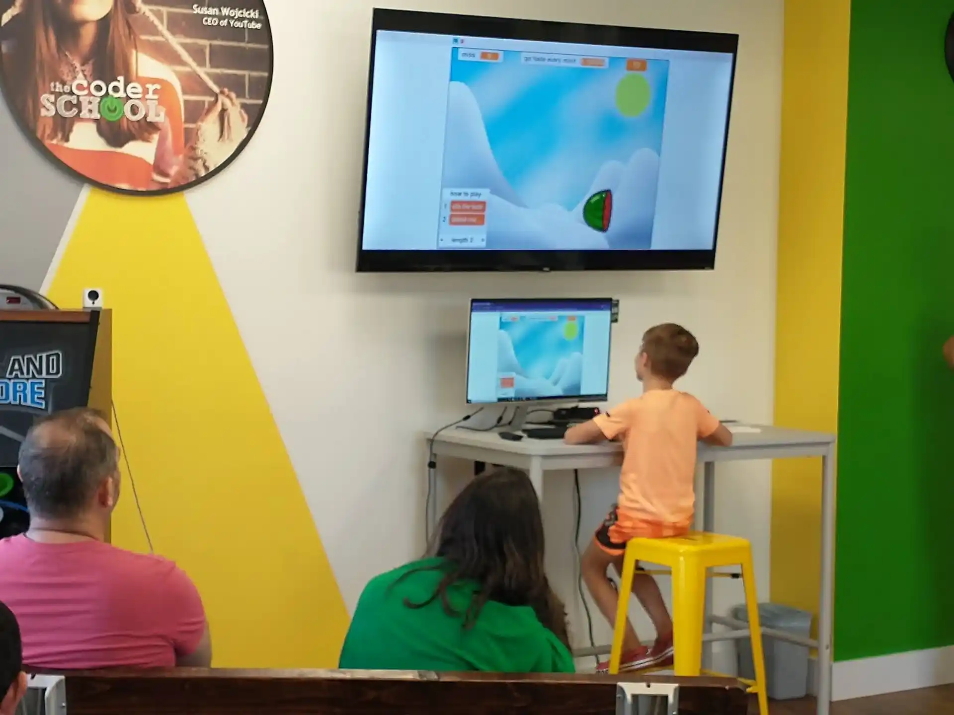 a group of people sitting at desks looking at a screen