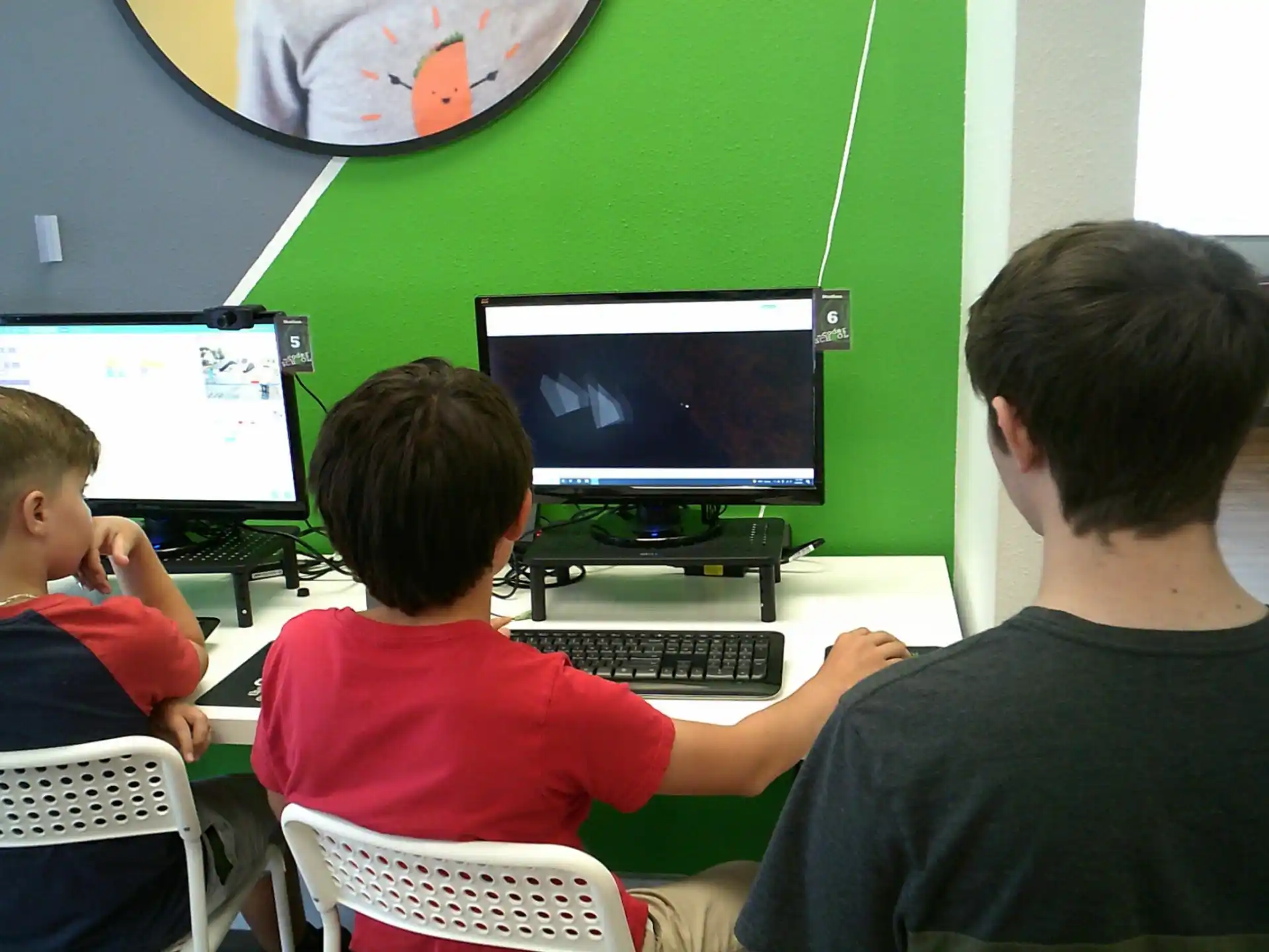 a group of people sitting in front of a computer