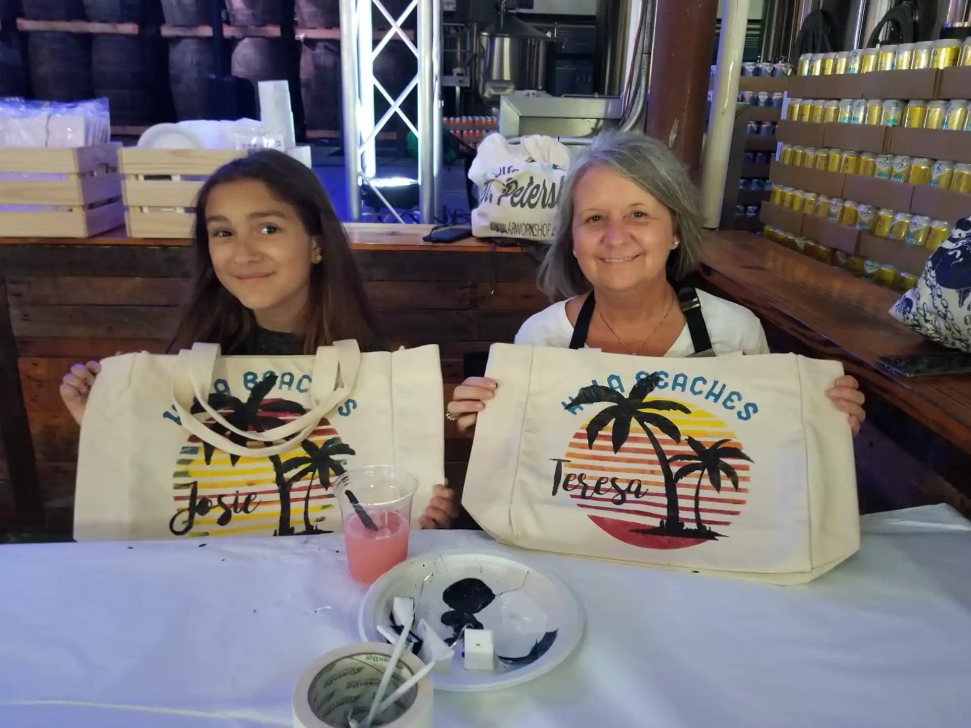 a couple of women sitting at a table holding up a sign