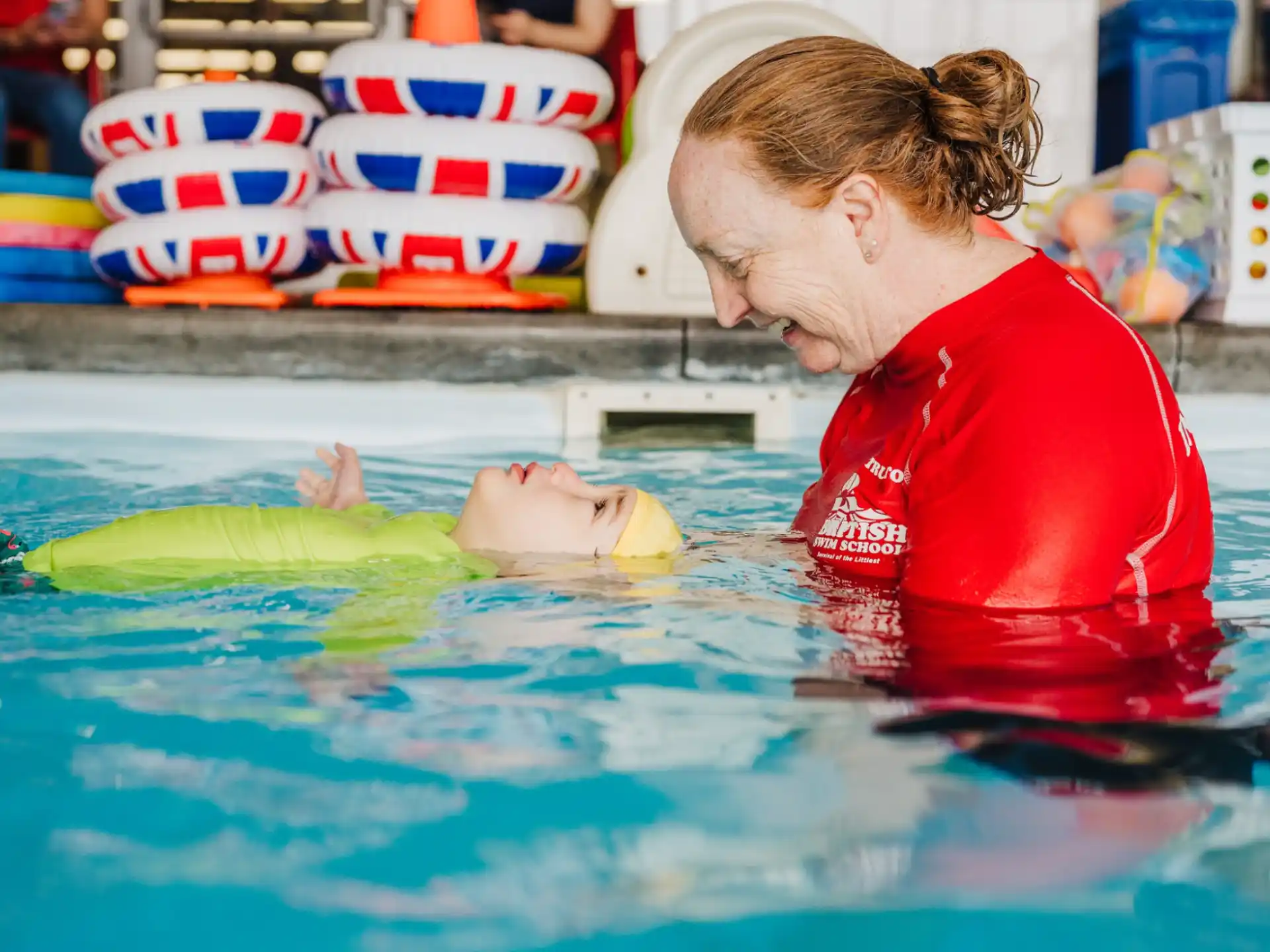 a person in a pool with a dolphin