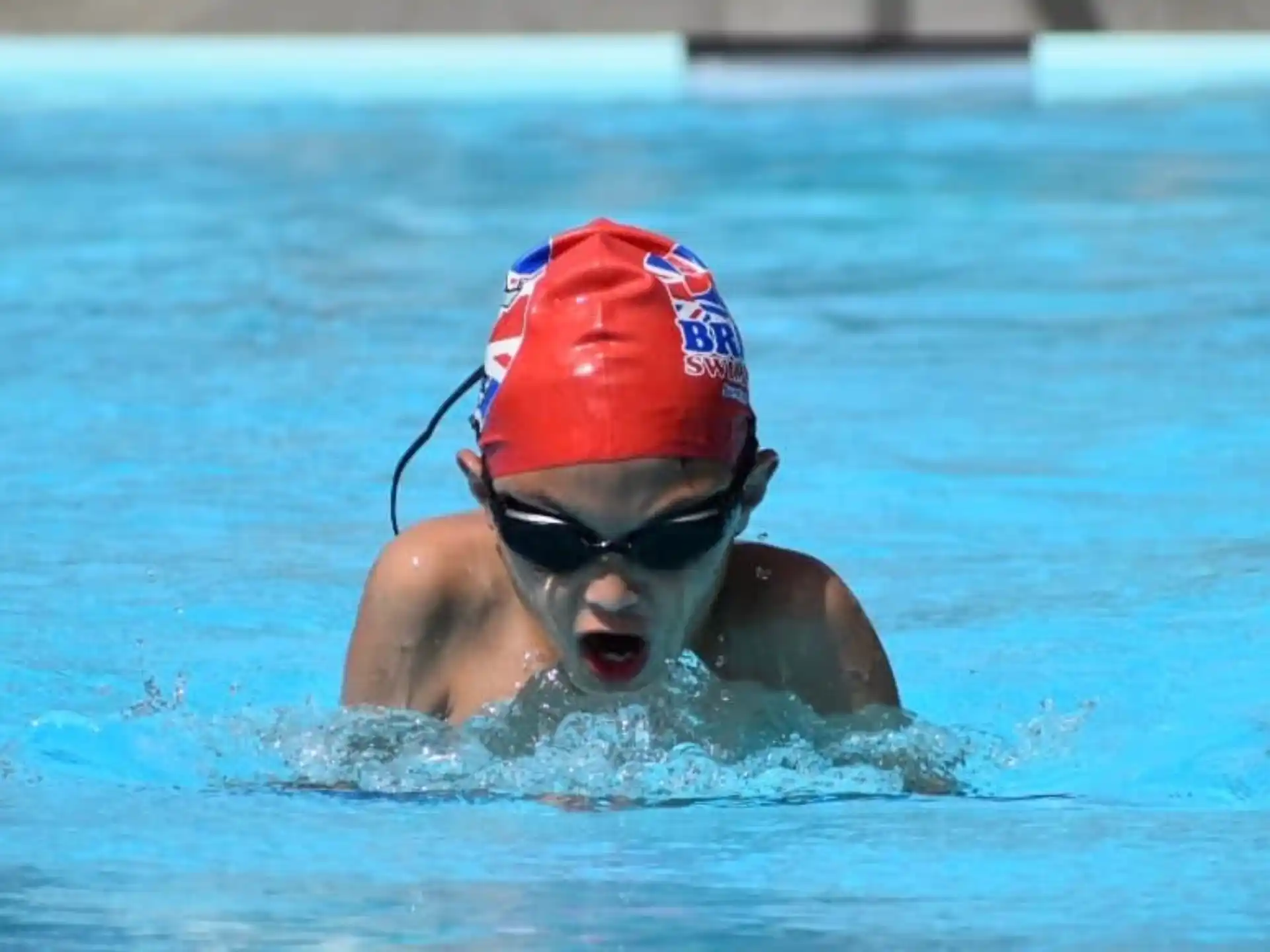 a person in a pool wearing goggles and a life jacket
